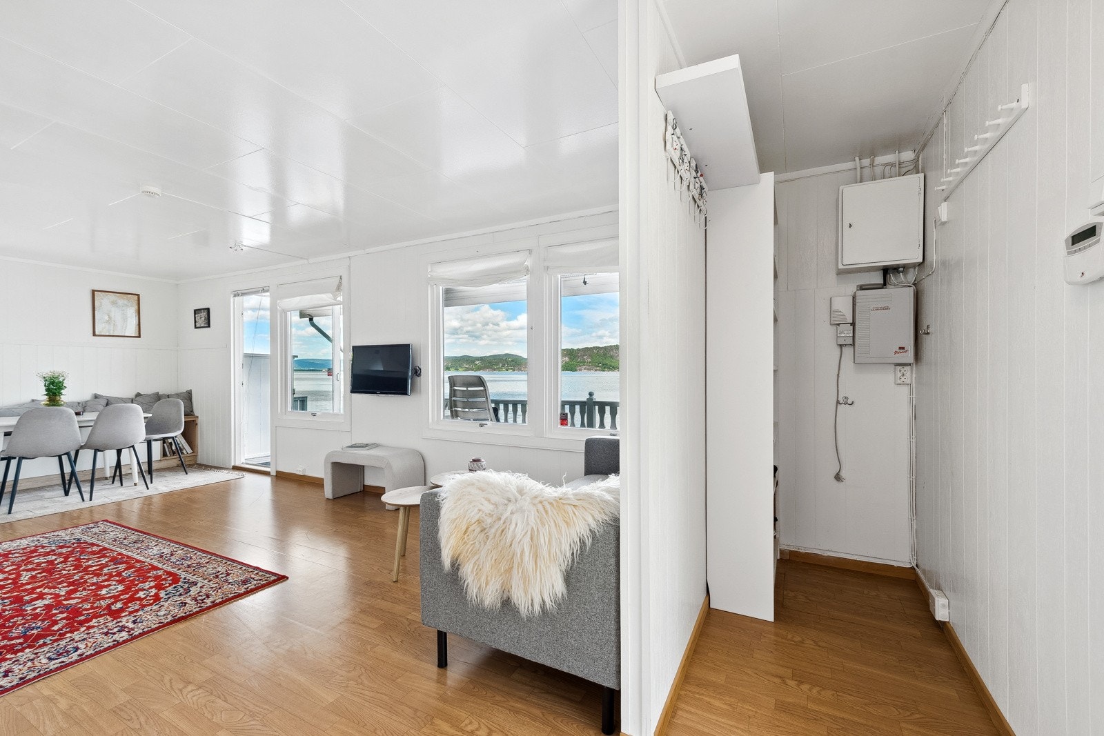 Inne i fritidsboligen er det en liten gang samt oppholdsrom med stue og kjøkken Galleribilde