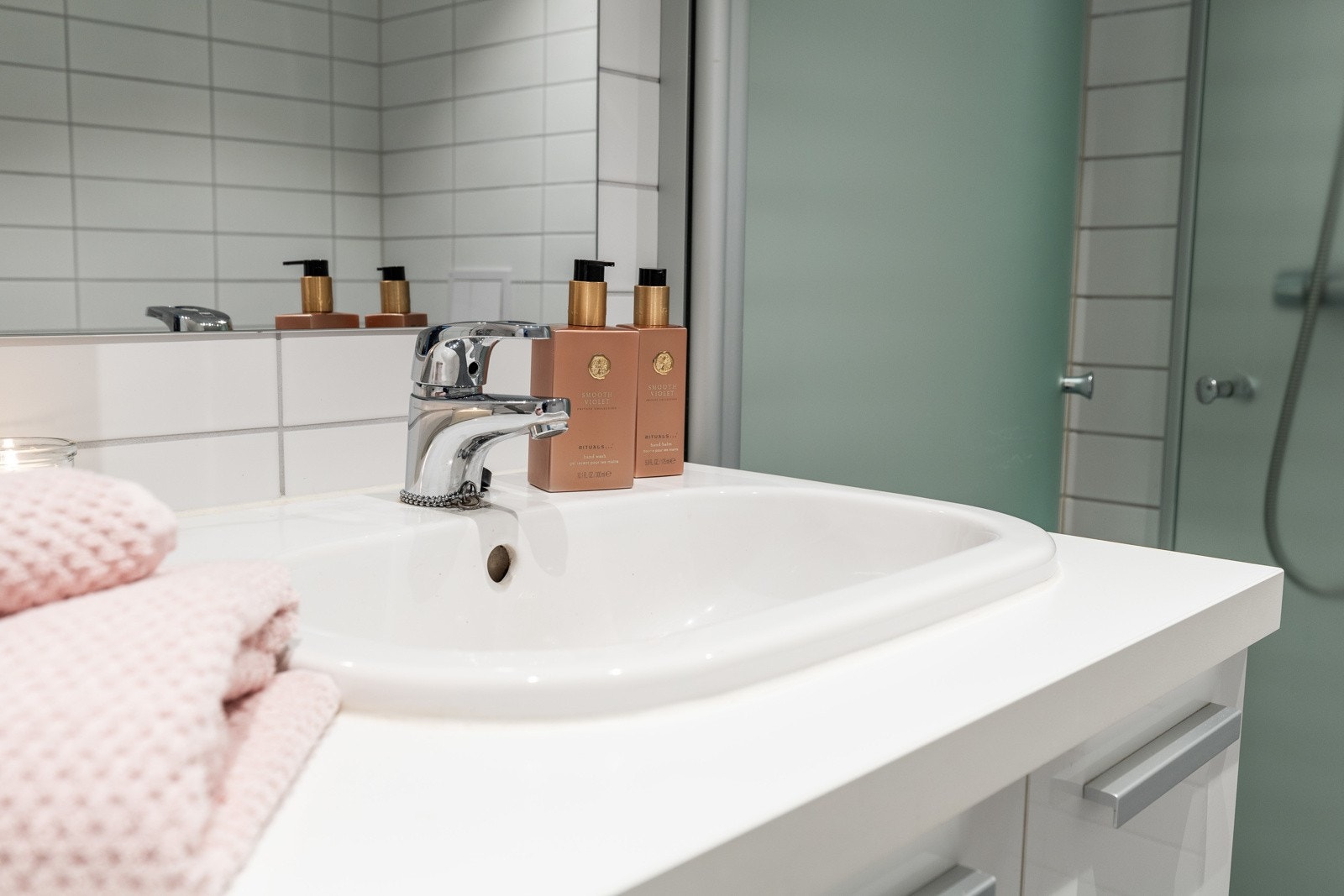 Badet fremstår som moderne og velholdt, med hvite fliser på veggene, downlights i himlingen og grå fliser på gulv med gulvvarme. Galleribilde