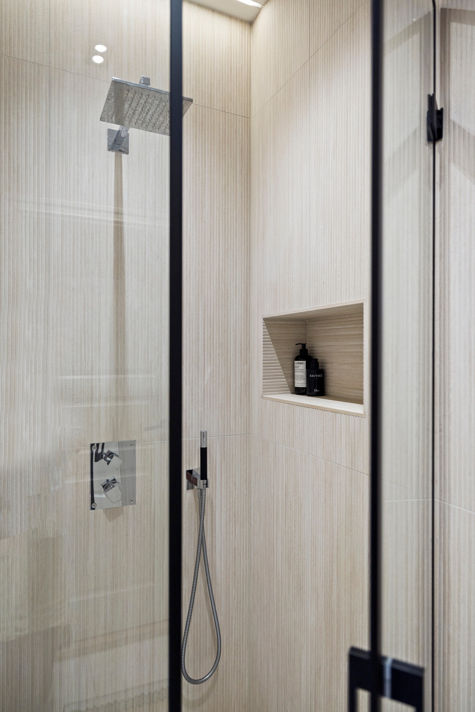 Badet består av veggmontert servant, veggmontert speil med integrert belysning. Dusjhjørne med glassdører, kantsluk, regndusj og termostatstyrt blandebatteri samt veggmontert toalett Galleribilde