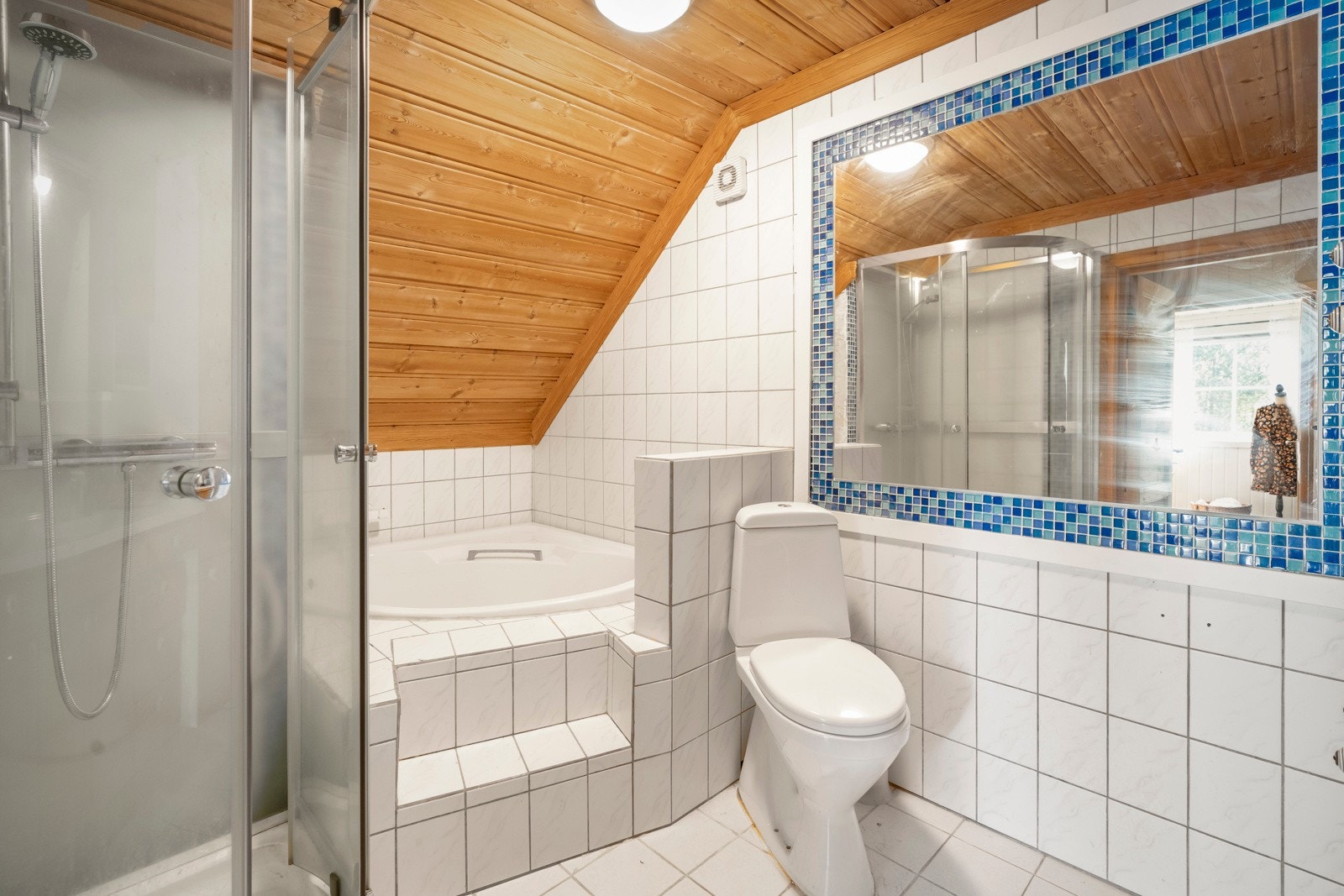 Badet er utstyrt med badekar, dusjkabinett, toalett og servant med underskap. Galleribilde