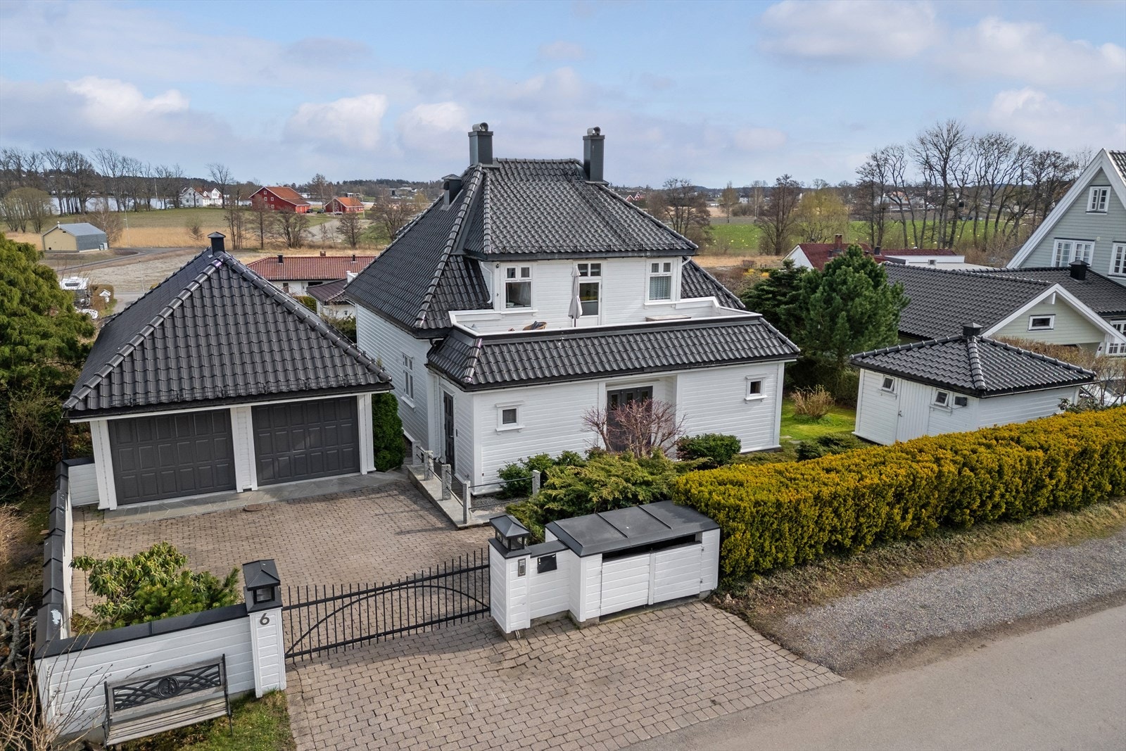 Pen hellebelagt innkjørsel med sort smijernsport. Galleribilde