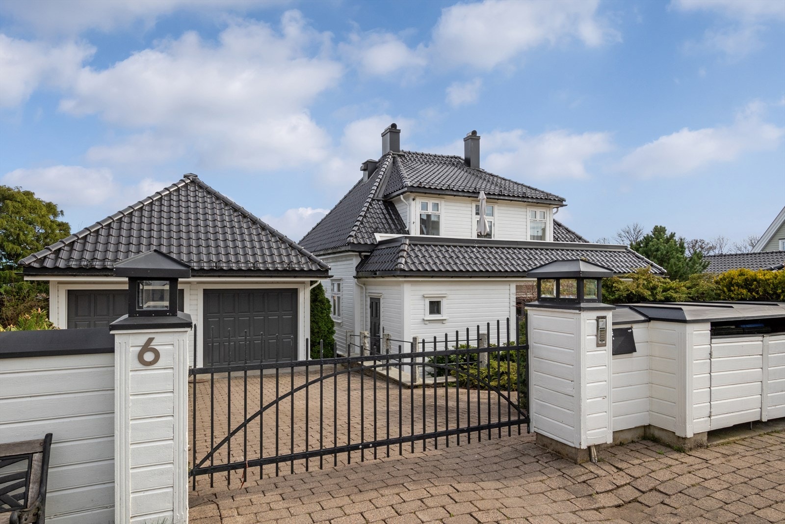 Huset er godt skjermet mot vei og naboer. Sort smijernsport inn til eiendommen med automatisk portåpner, det er også callinganlegg fra utvendig port. Galleribilde