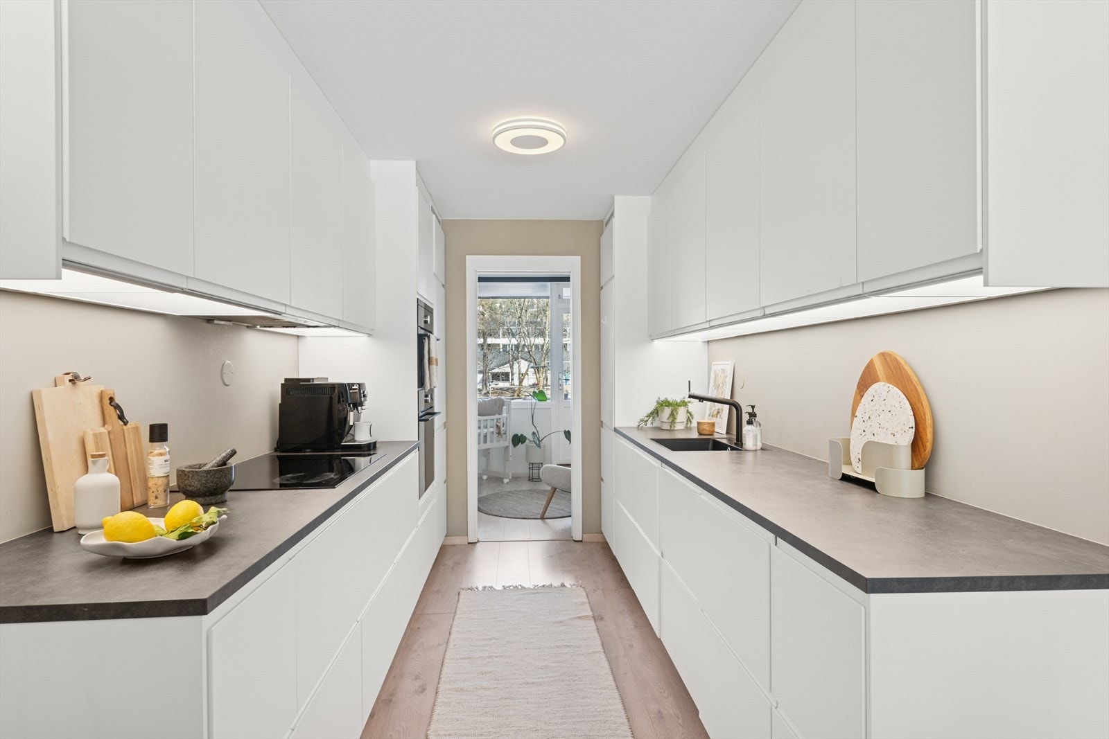 Kjøkkeninnredningen er fra 2019 og er moderne utført med hvite, glatte fronter og mørk laminat benkeplate med nedfelt kjøkkenkum. Galleribilde