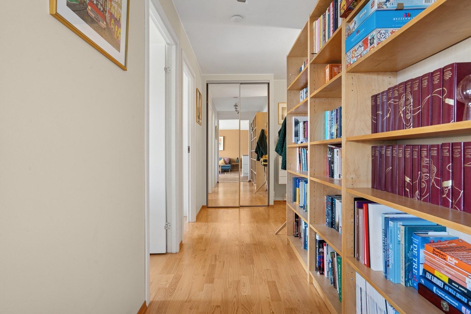 I tillegg er det en praktisk 2-dørs skyvedørsgarderobe med speilfronter og bokhylle langs veggen. Galleribilde