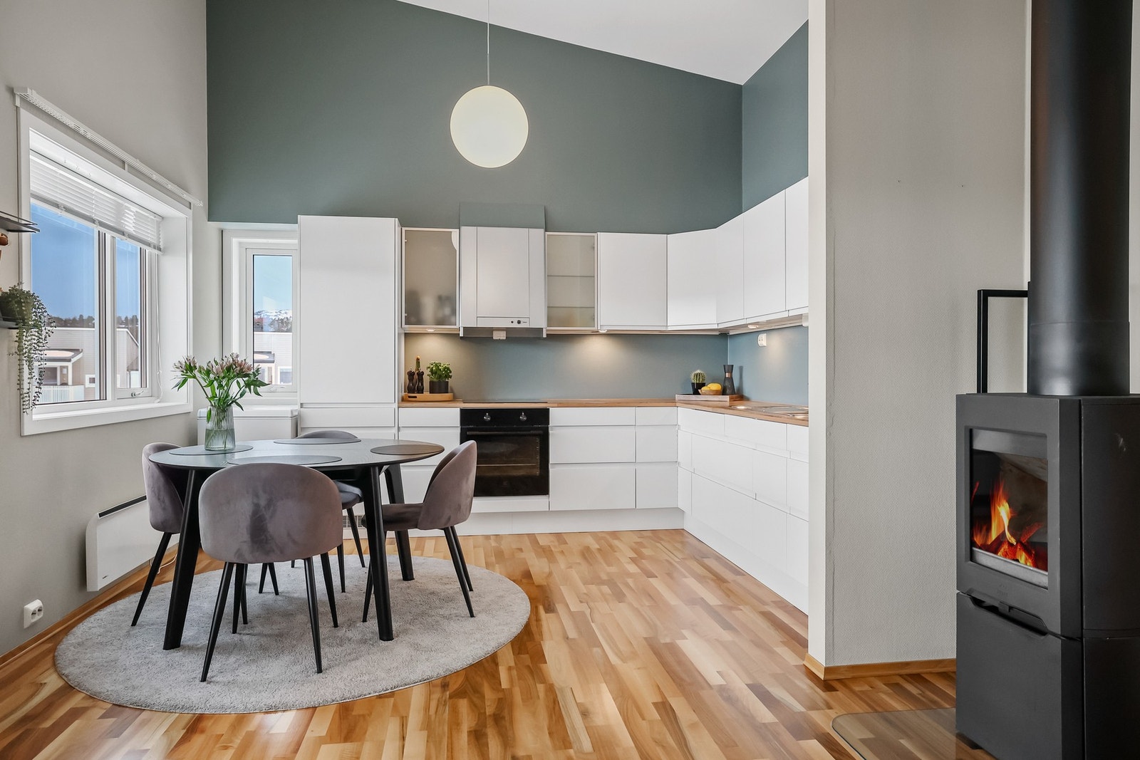 De lyse veggene og laminatgulvene gir rommet en tidløs og moderne stil, mens peisovnen i stuen tilfører både varme og hygge på kjølige dager. Galleribilde