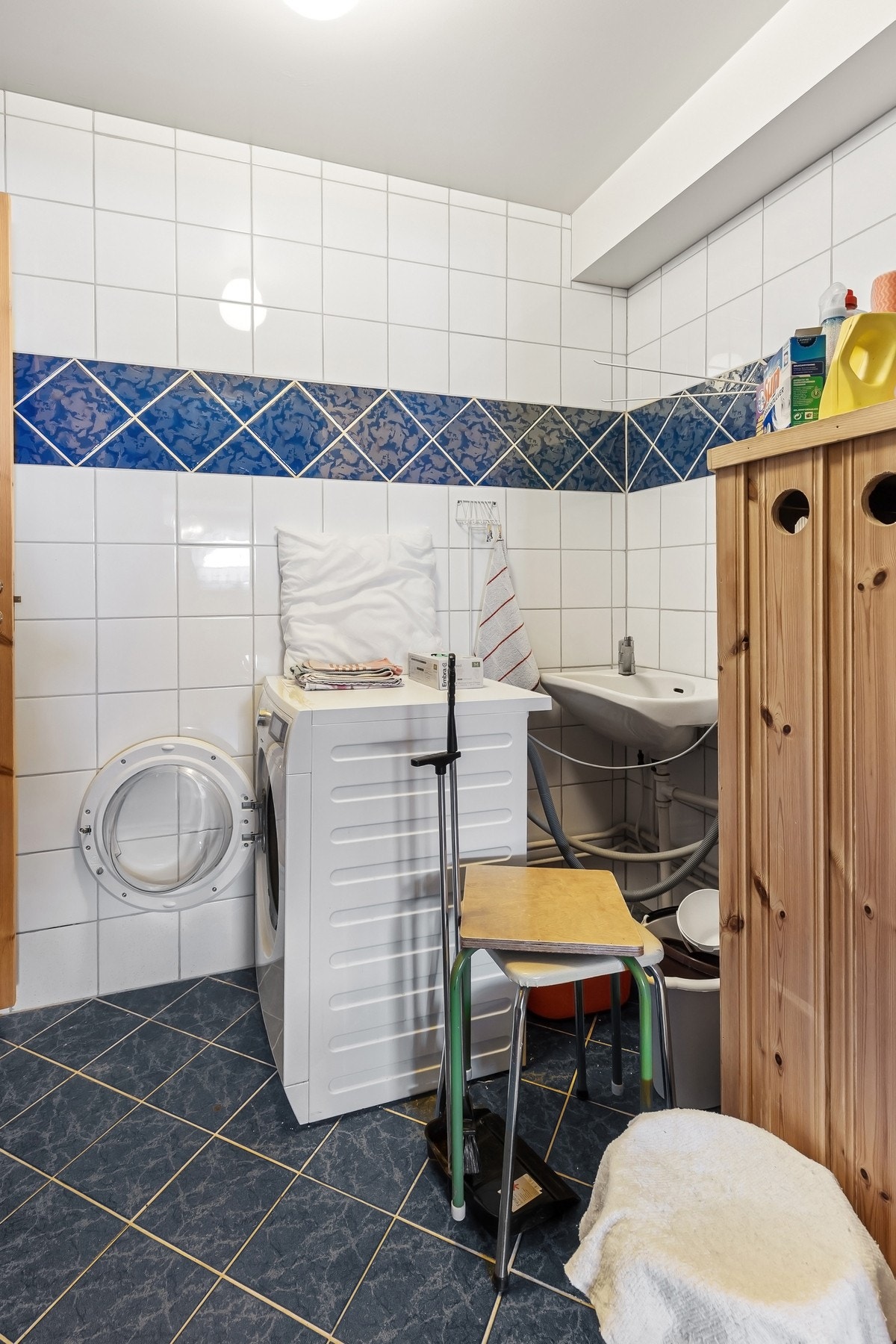 Praktisk vaskerom med vaskekum, varmtvannsbereder og opplegg for vaskemaskin. Galleribilde