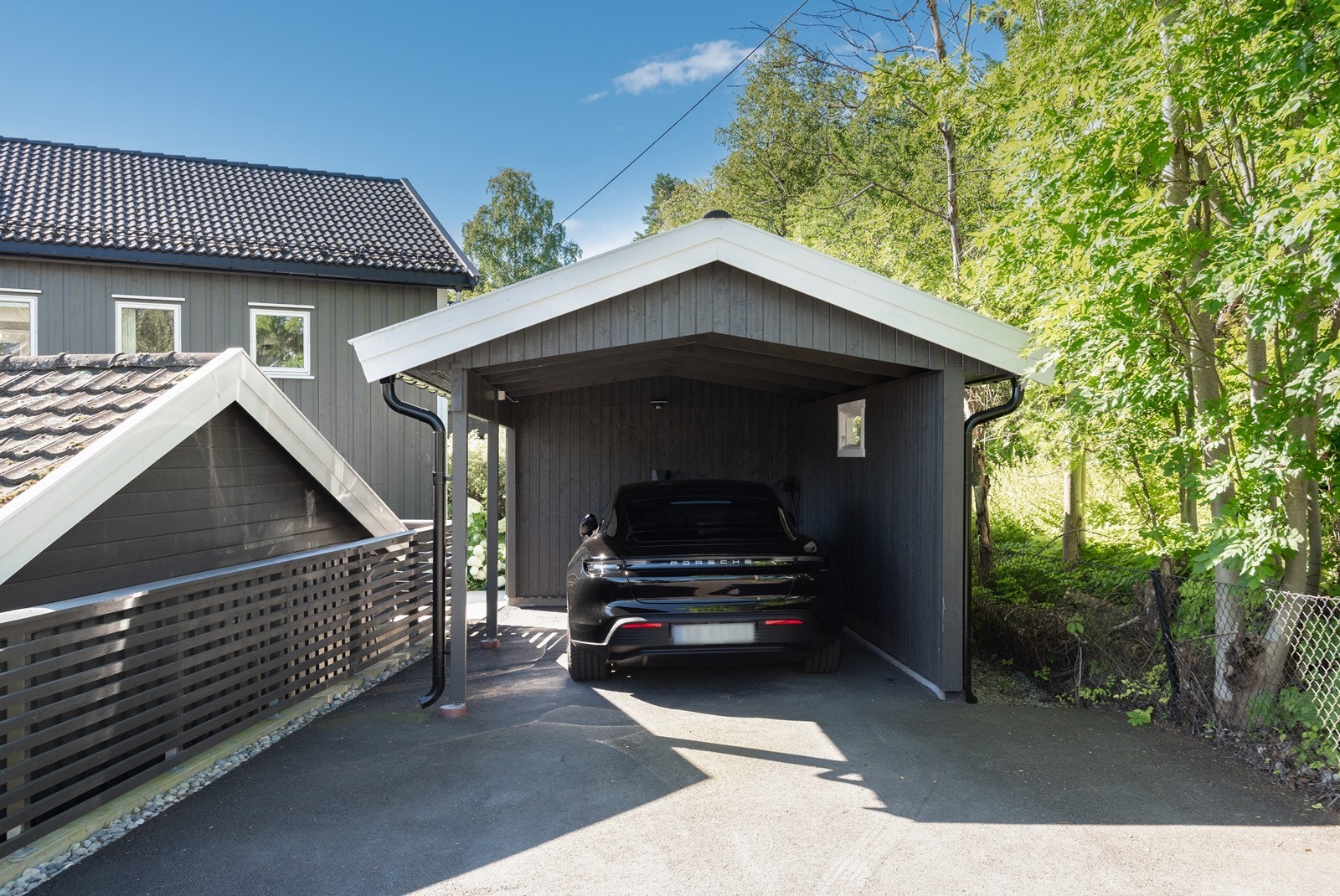 Nyoppført carport med bod i bakkant, trapp ned til inngangspartiet. Galleribilde