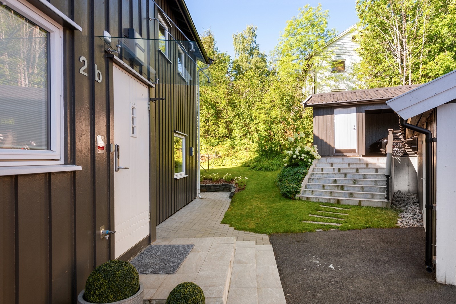 Pent inngangsparti, nyere carport med bod og en stor dobbelgarasje som er deles med nabo. Galleribilde
