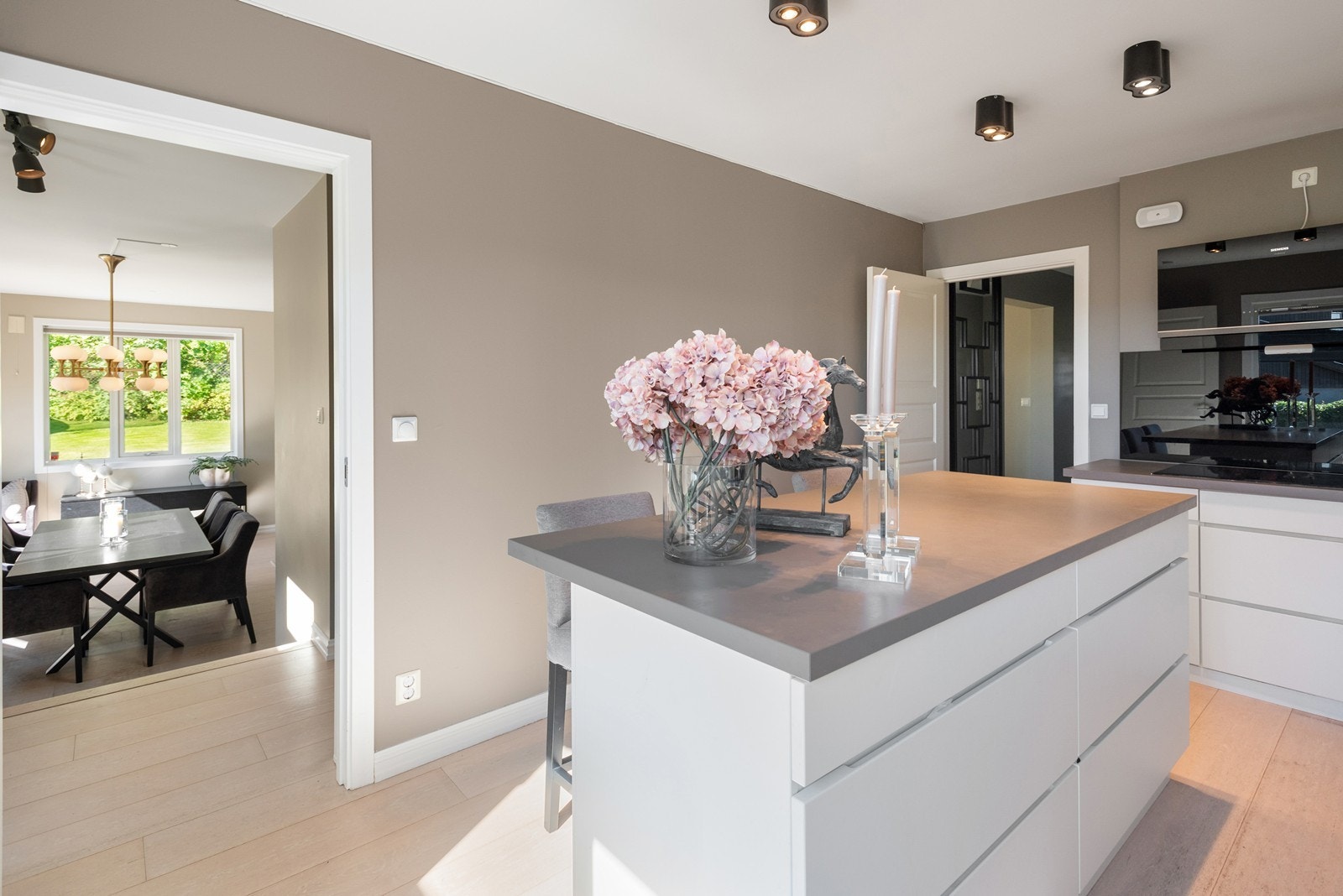 Pent og lys kjøkken i praktisk avstand fra spisestue og stue Galleribilde