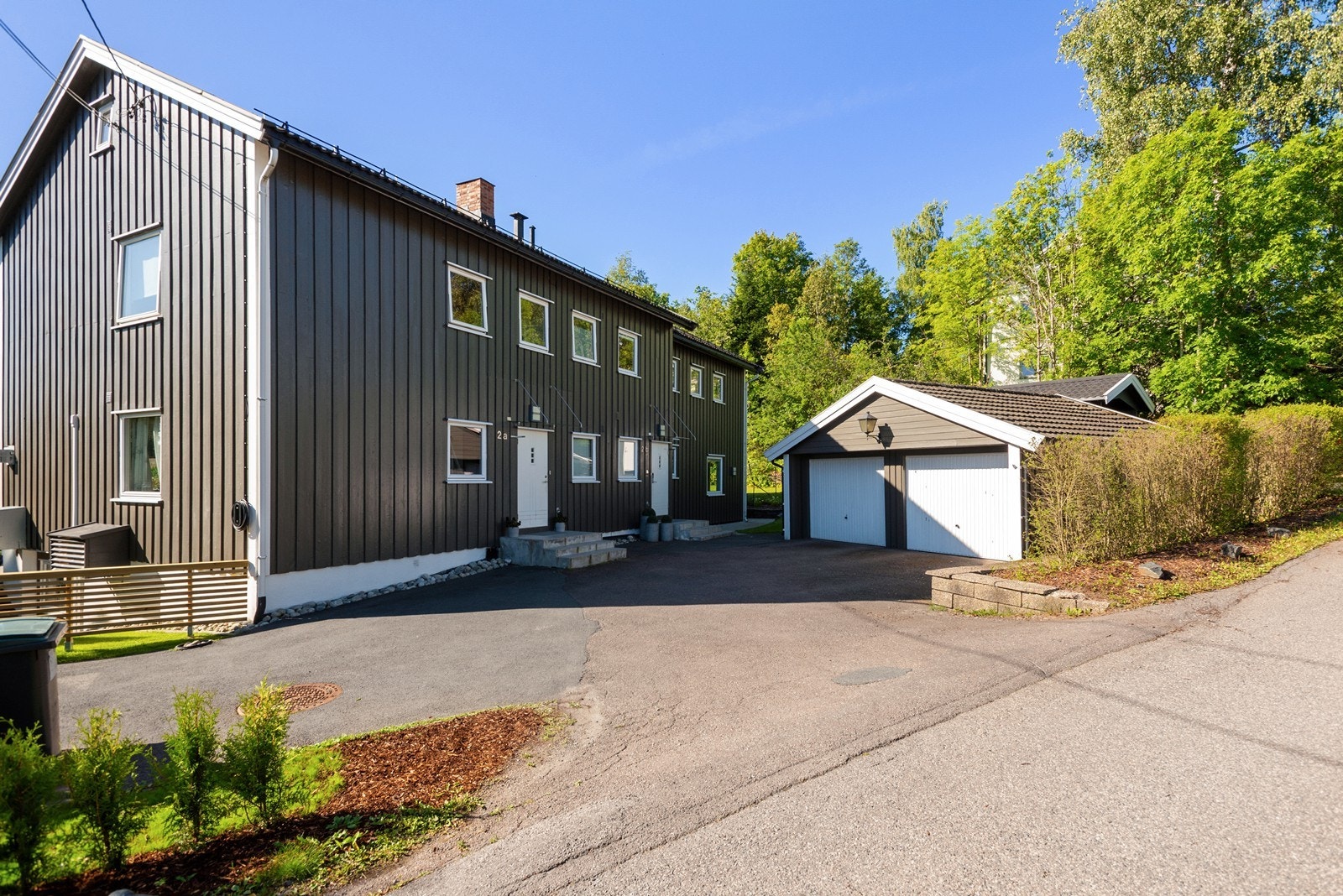 Felles adkomstparti, garasjen deles med nabo, plassen til venstre tilhører 2B. I bakkant ser man oppført carport. Galleribilde