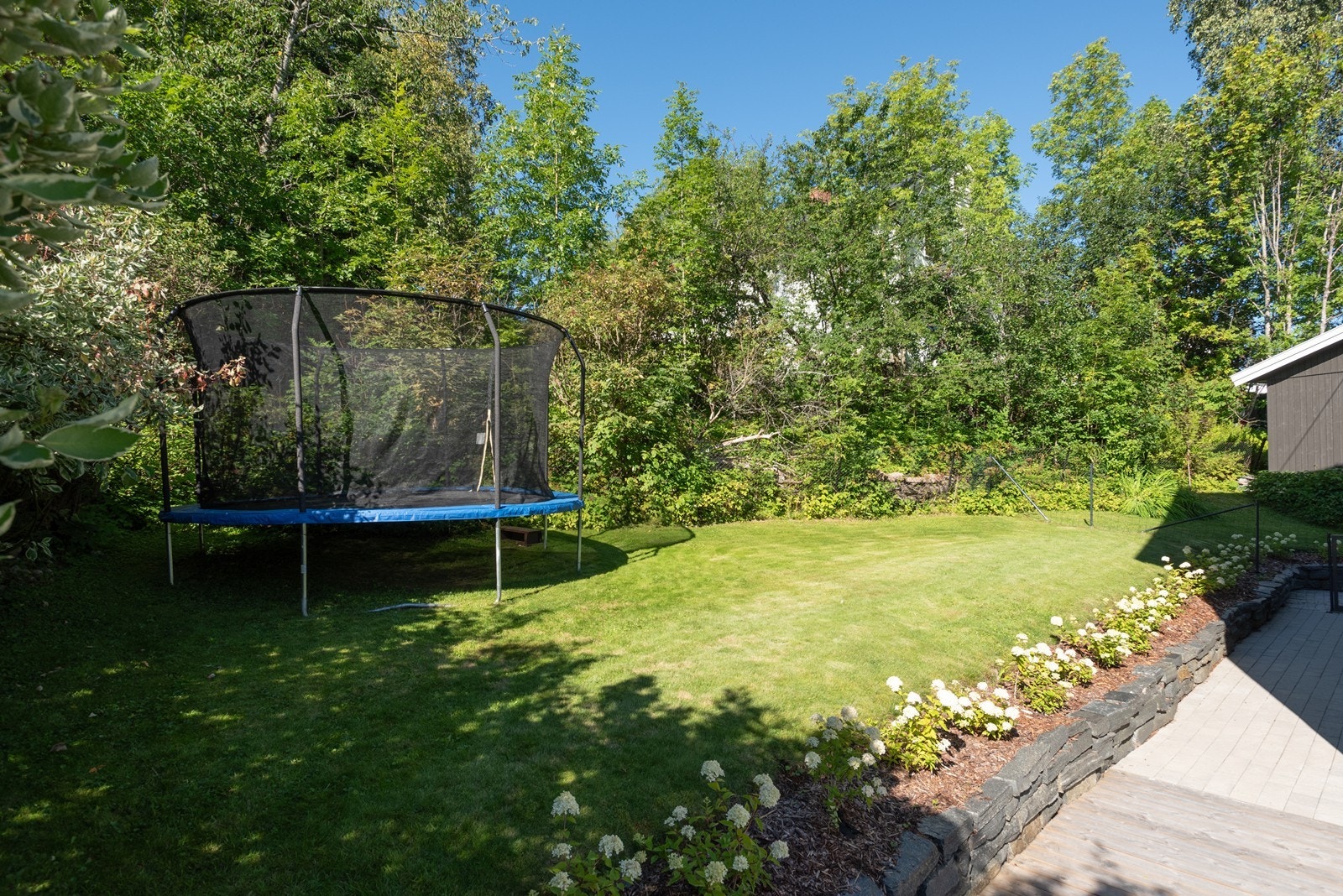 Hagen er stor og har store områder med flat gressplen, gjerde med port ut mot garasje og gårdsplass. Galleribilde