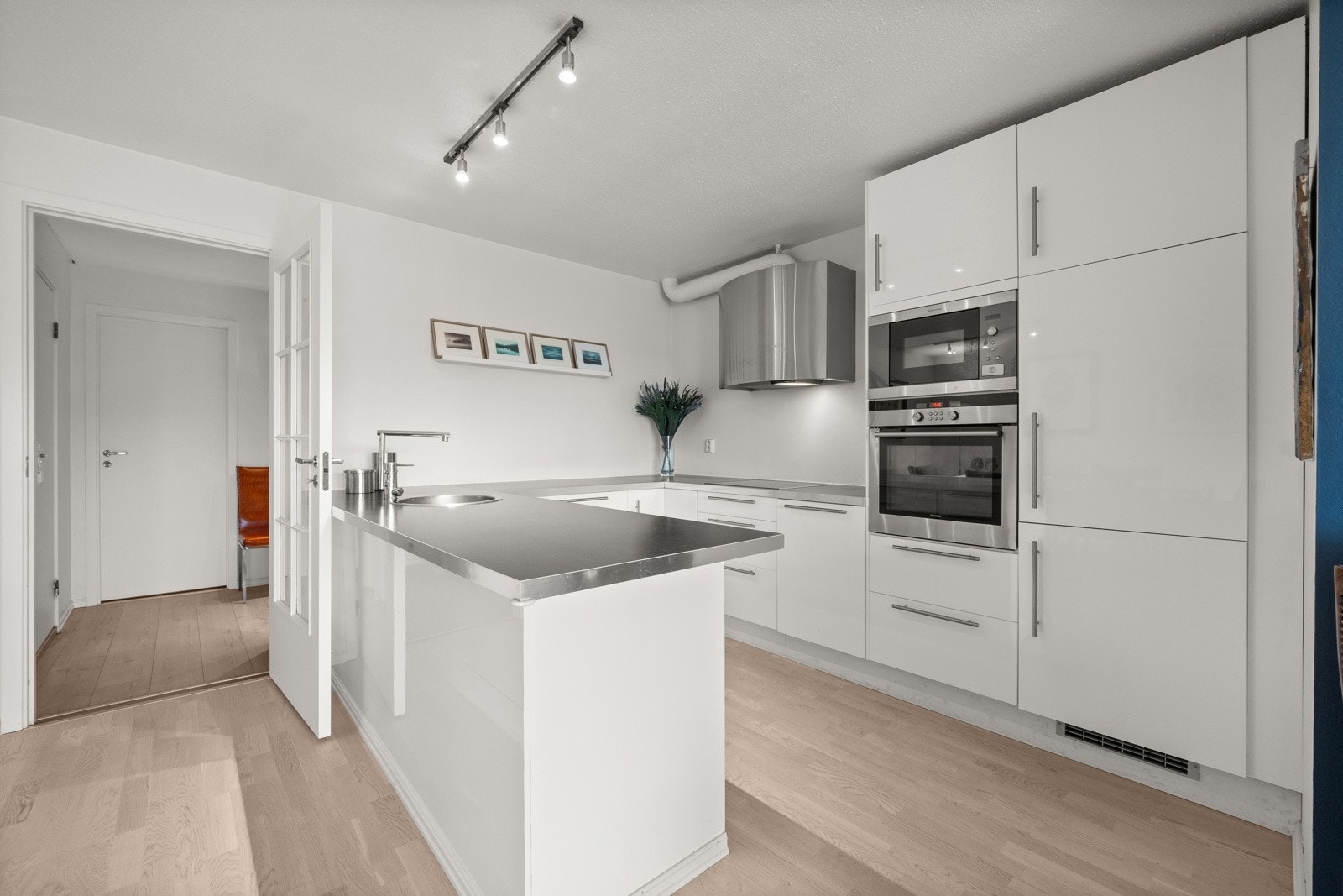 Innholdsrikt og moderne kjøkken med innredning holdt i lyse farger Galleribilde