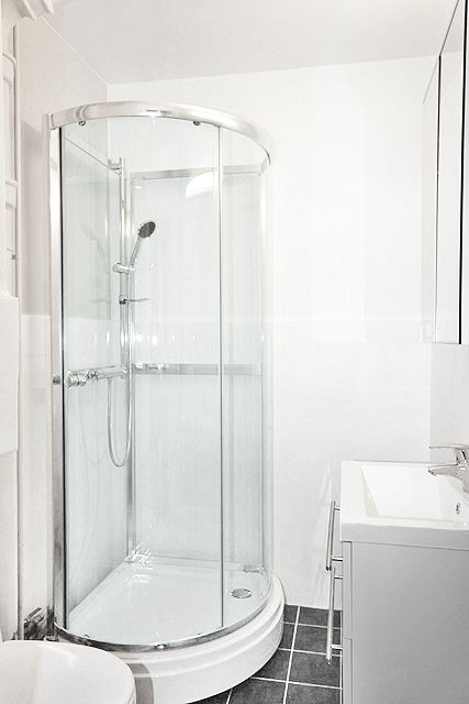 Badet er utstyrt med dusjkabinett, toalett og servant med under- og overskap. Galleribilde