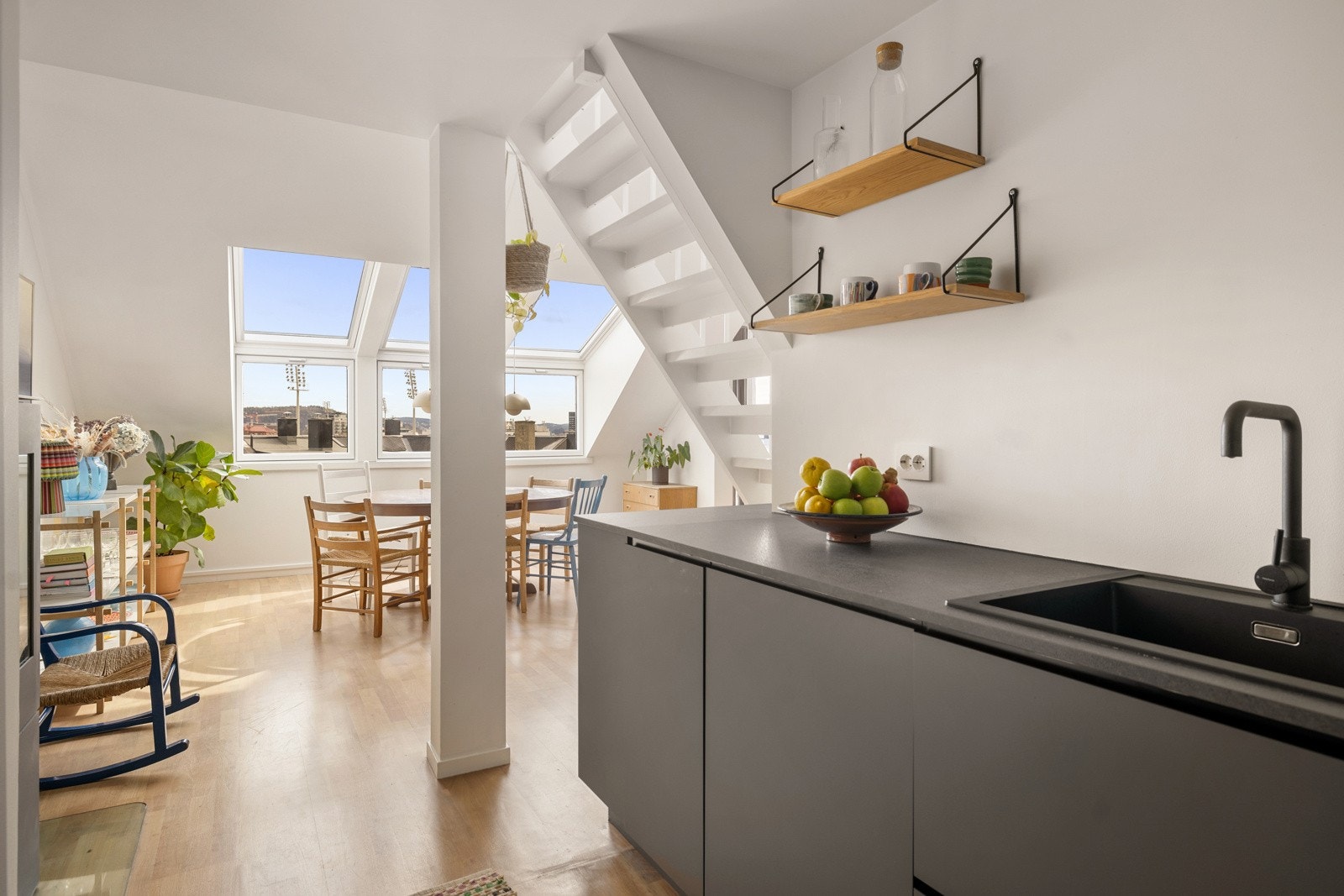 Kjøkkenet ligger lunt plassert under trappen, skjermet men likevel åpent mot stue og spiseplass - perfekt for både hverdag og gjester. Galleribilde