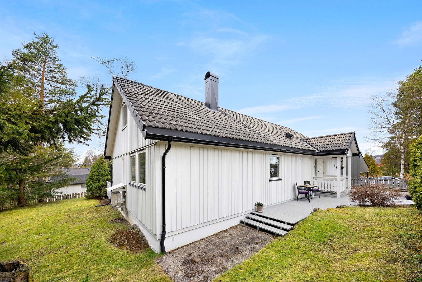 Tomten er pent opparbeidet med plen og gruset gårdsplass Galleribilde