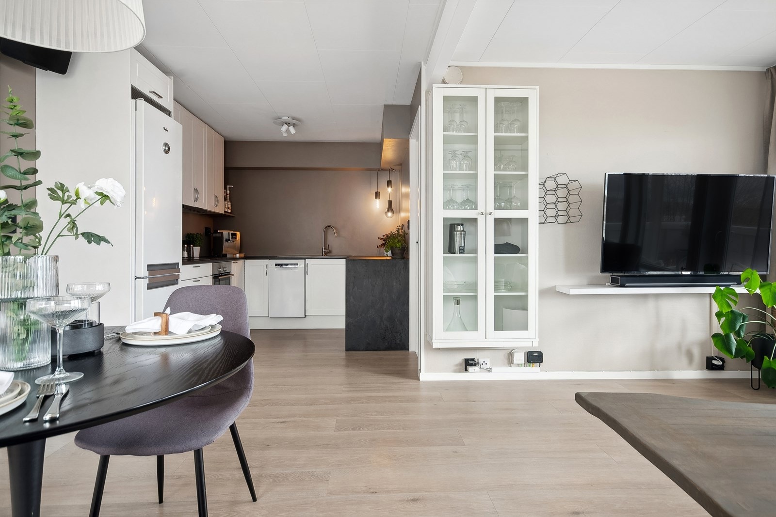 Kjøkkeninnredningen er stilren med hvite profilerte fronter og laminat benkeplate med nedfelt vask m/benkebeslag Galleribilde