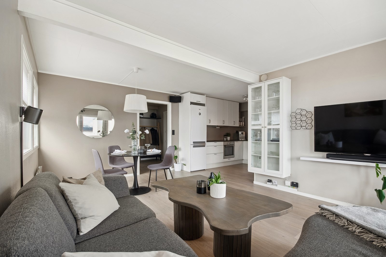 Stuen er innbydende med vegger malt i en tidsriktig farge og laminatgulv fra 2022 (nytt gulv i entrè, stue/kjøkken og begge soverommene) Galleribilde