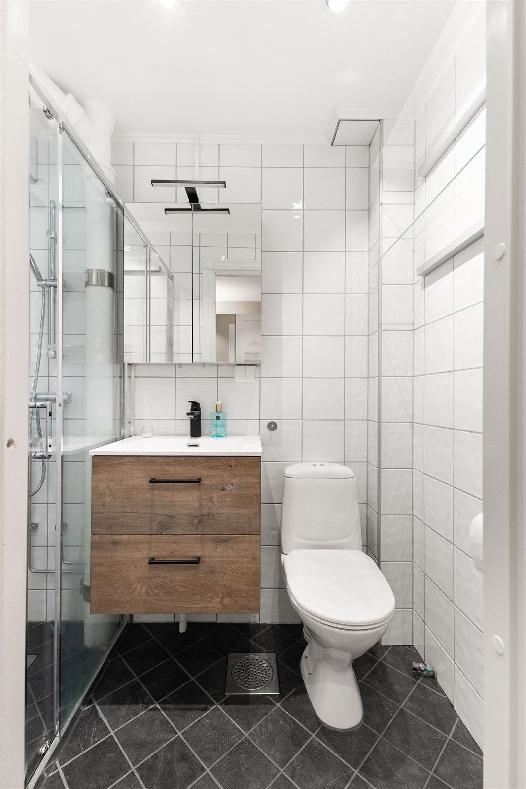 Pent flislagt baderom med servant og blandebatteri fra 2020. Det er fellesvaskeri i bygget. Galleribilde