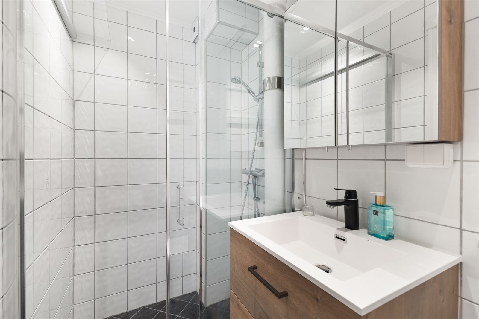 Badet har praktisk dusjhjørne, servant og speil med innredning og toalett. Det opplyses om at det er varmekabler på bad som ikke fungerer. Galleribilde