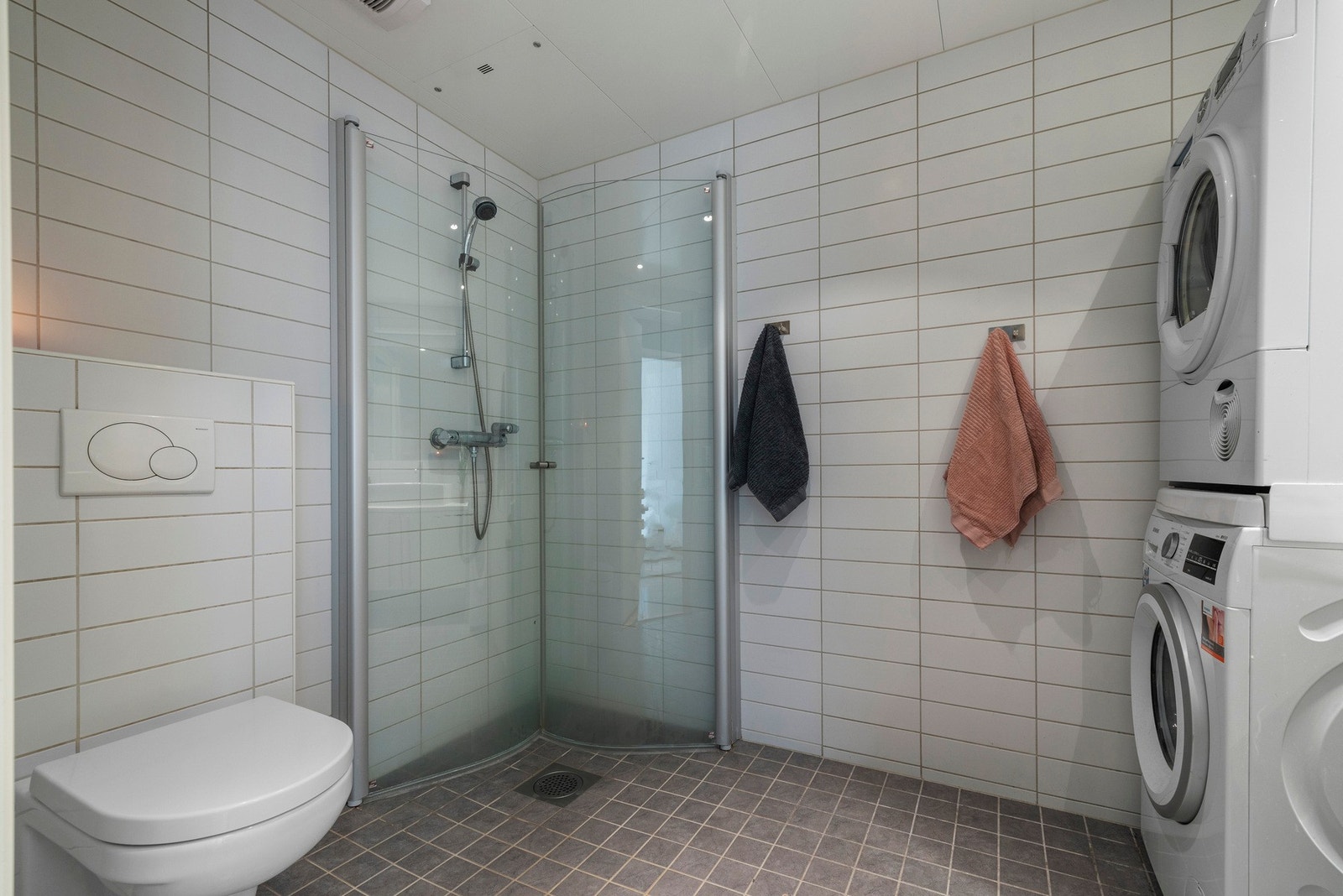 Badet er stilrent med flislagt gulv og vegger. Galleribilde