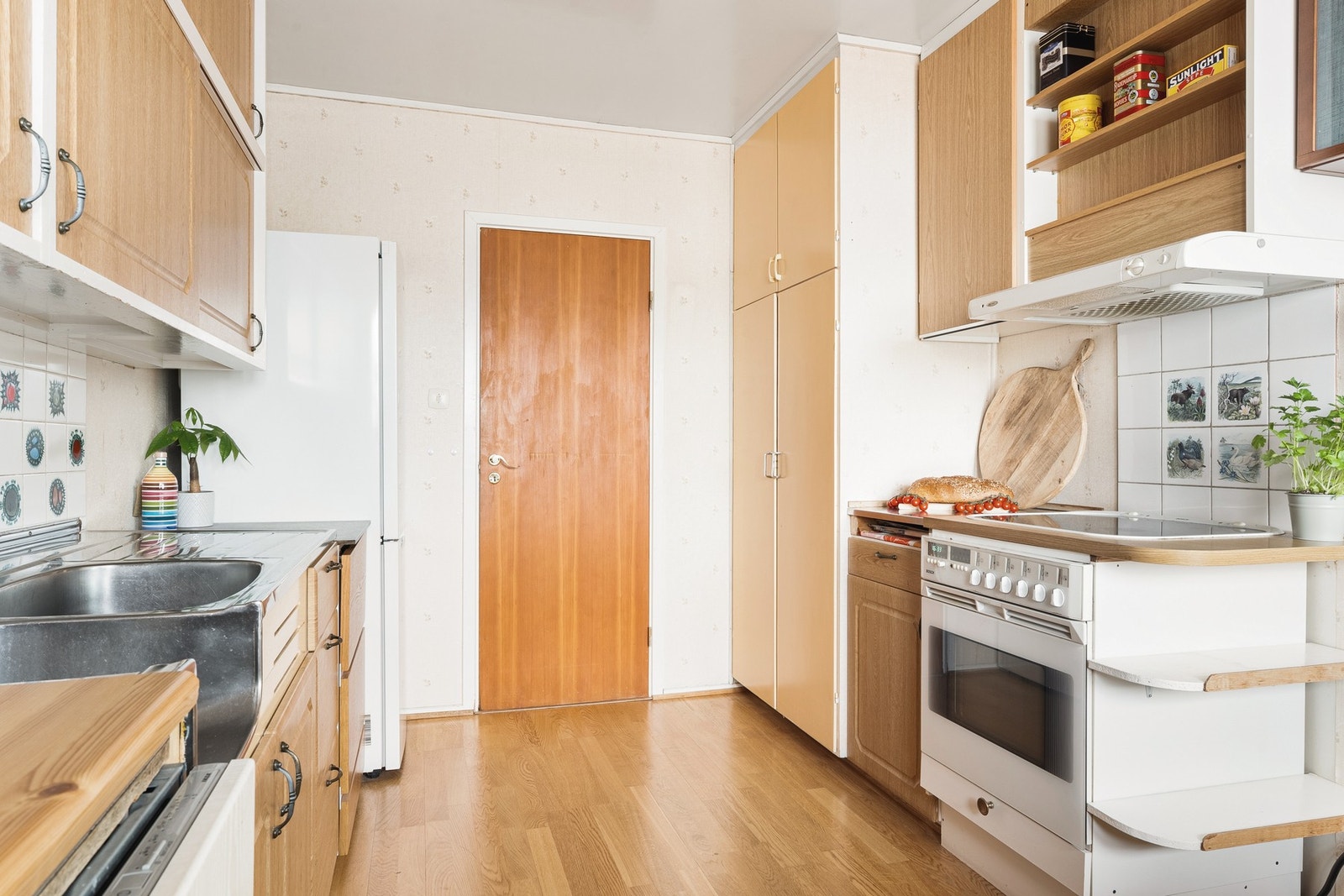 Innredningen er av eldre dato, med slette og profilerte fronter, stålvask med stålbenk og laminert benkeplate. Galleribilde