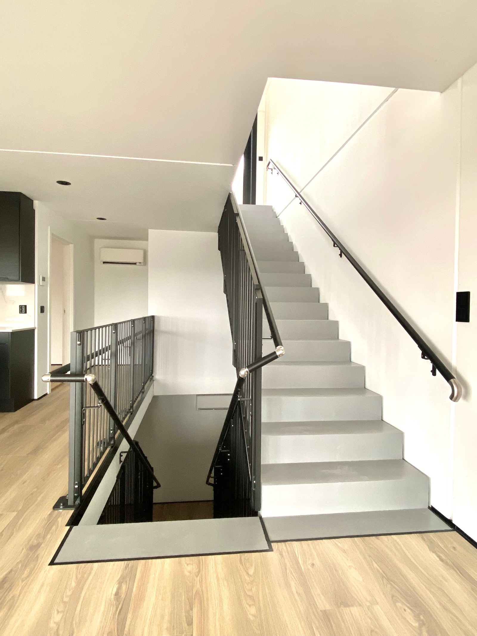 Røffe betongtrapper mellom etasjene i massiv betong og med stålrekkverk Galleribilde