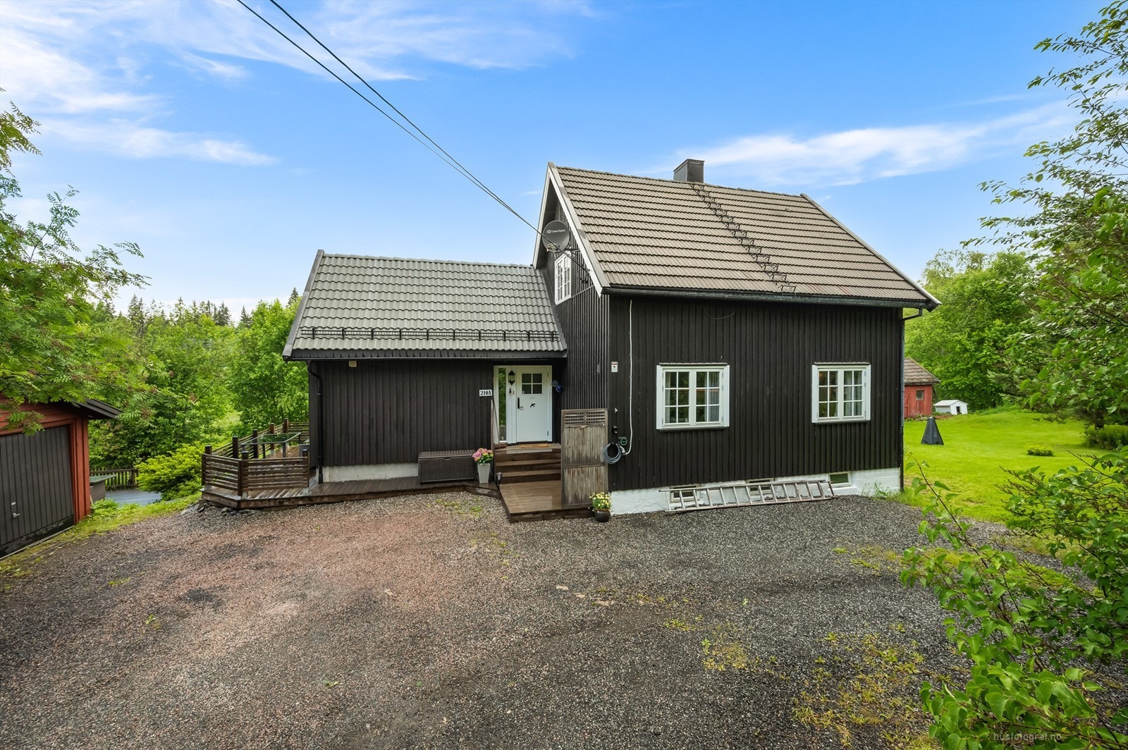 Gruset gårdsplass med el-billader fra 2020 på husveggen Galleribilde