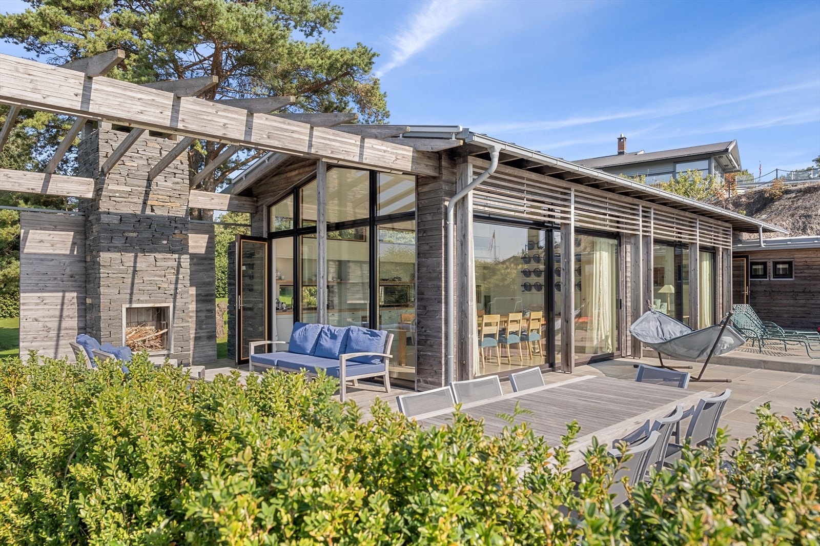 Hyttas flotte glassfasader mot sydvest gir rikelig med dagslys inn og visker nærmest ut skillet mellom ute og inne. Galleribilde