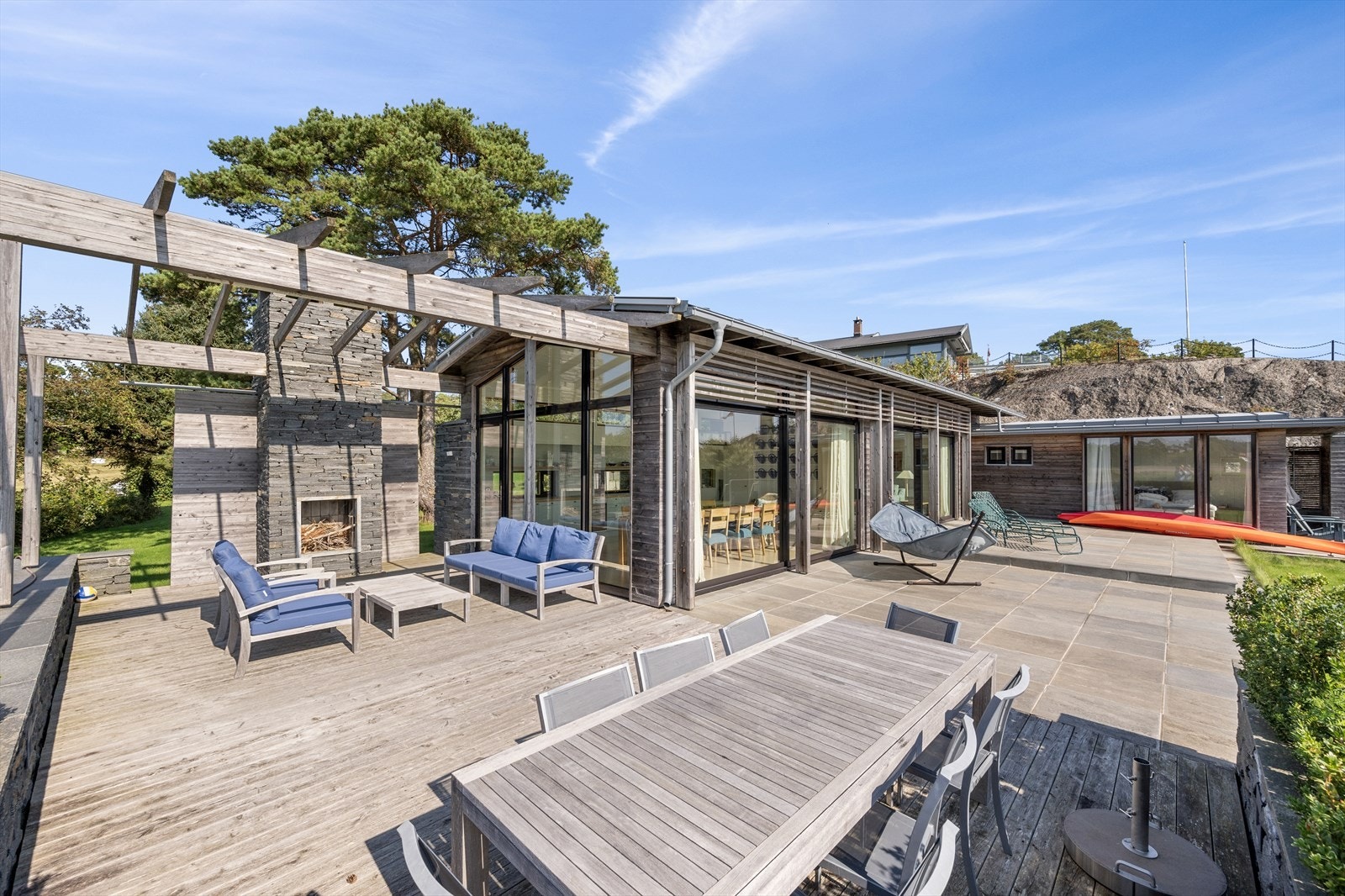 Ved pergolaen er det murt opp en flott utepeis, kledd i naturstein. Galleribilde