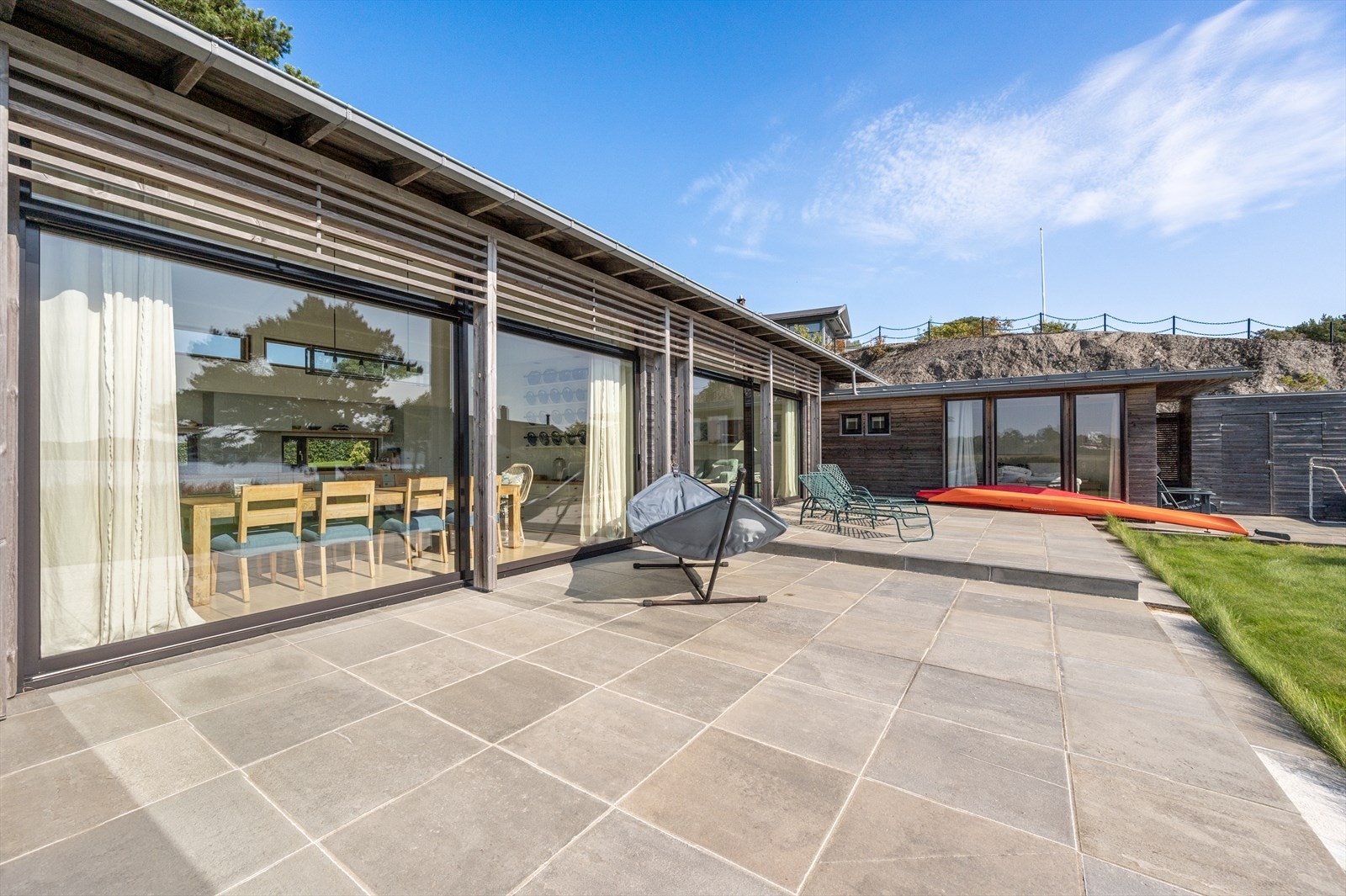 Stor skiferlagt terrasse utenfor stue og spisestue/kjøkken Galleribilde