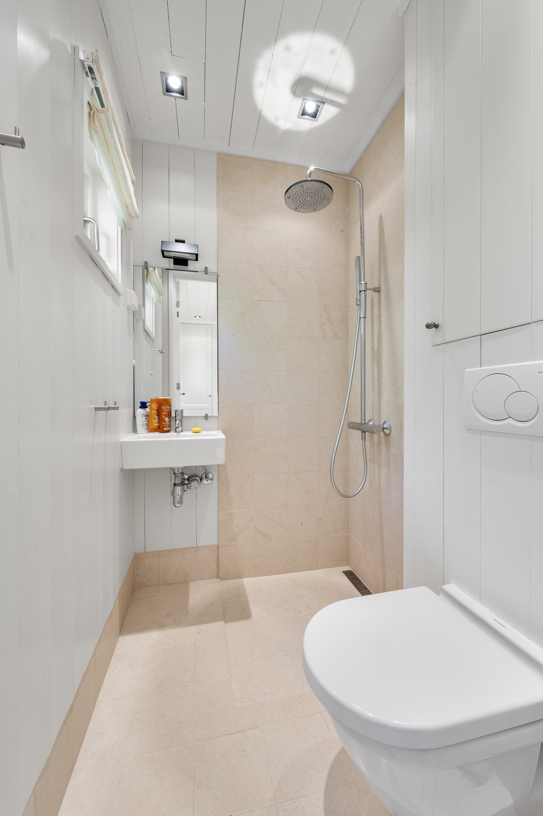 Hytta har tre pene bad i samme lyse utforming, med regnfallsdusj og veggmontert toalett. Galleribilde