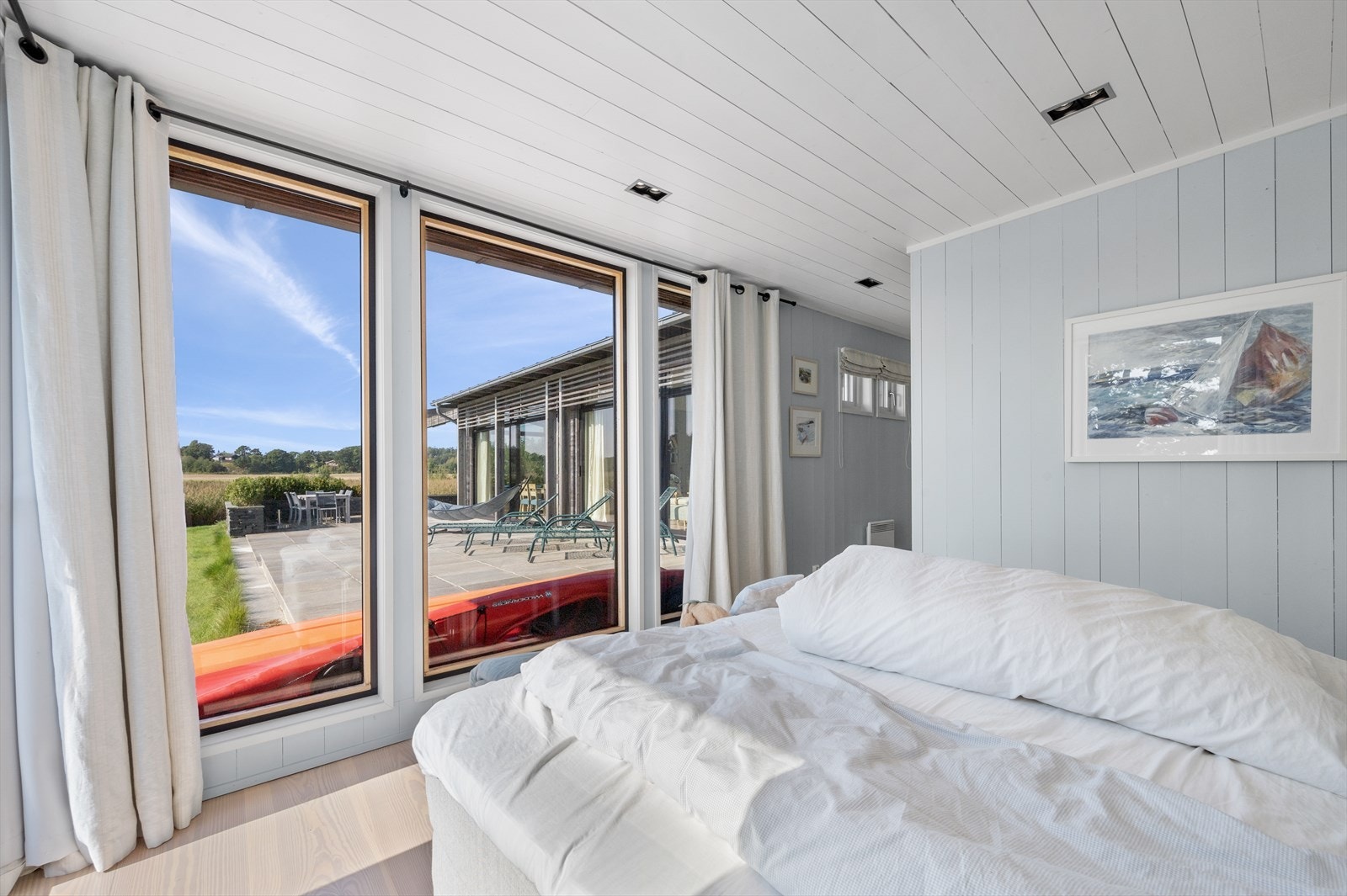 Rommet bades i dagslys og har nydelig utsikt til sjøen og landskapet, et herlig skue å våkne til. Galleribilde