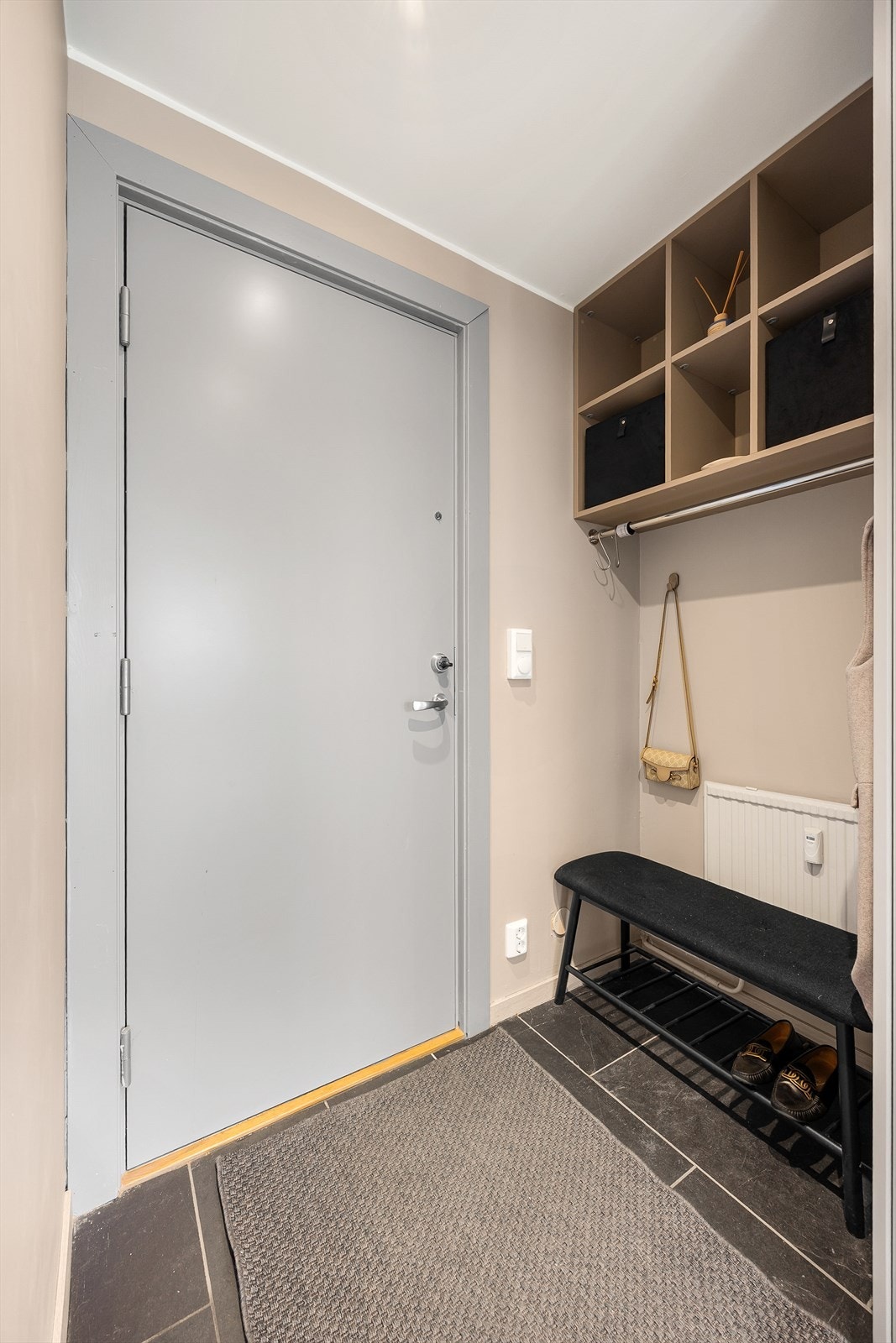 Lys og innbydende entré med nisje for yttertøy og sko. Flislagt og med radiator - perfekt for våte vinterdager. Galleribilde