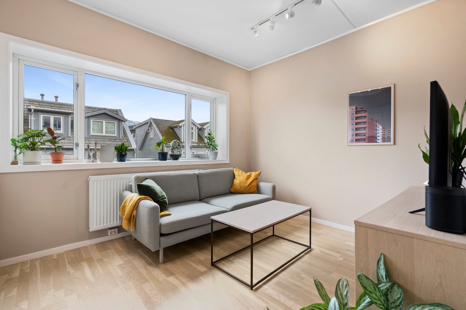 Den lyse og trivelige stuen er nymalt med duse fargevalg, og de store vindusflatene slipper inn rikelig med dagslys. Galleribilde