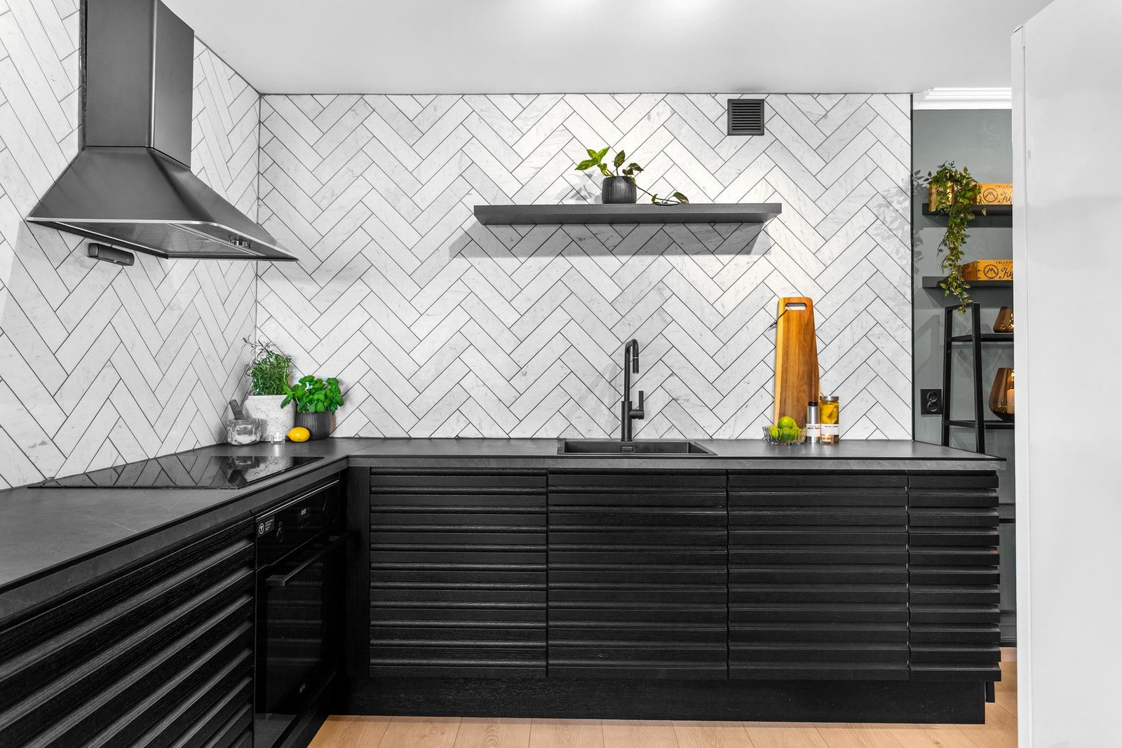 Integrerte hvitevarer som platetopp med kullfilterventilator, sort stekeovn, oppvaskmaskin, samt både frittstående kjøleskap og frittstående fryseskap. Galleribilde