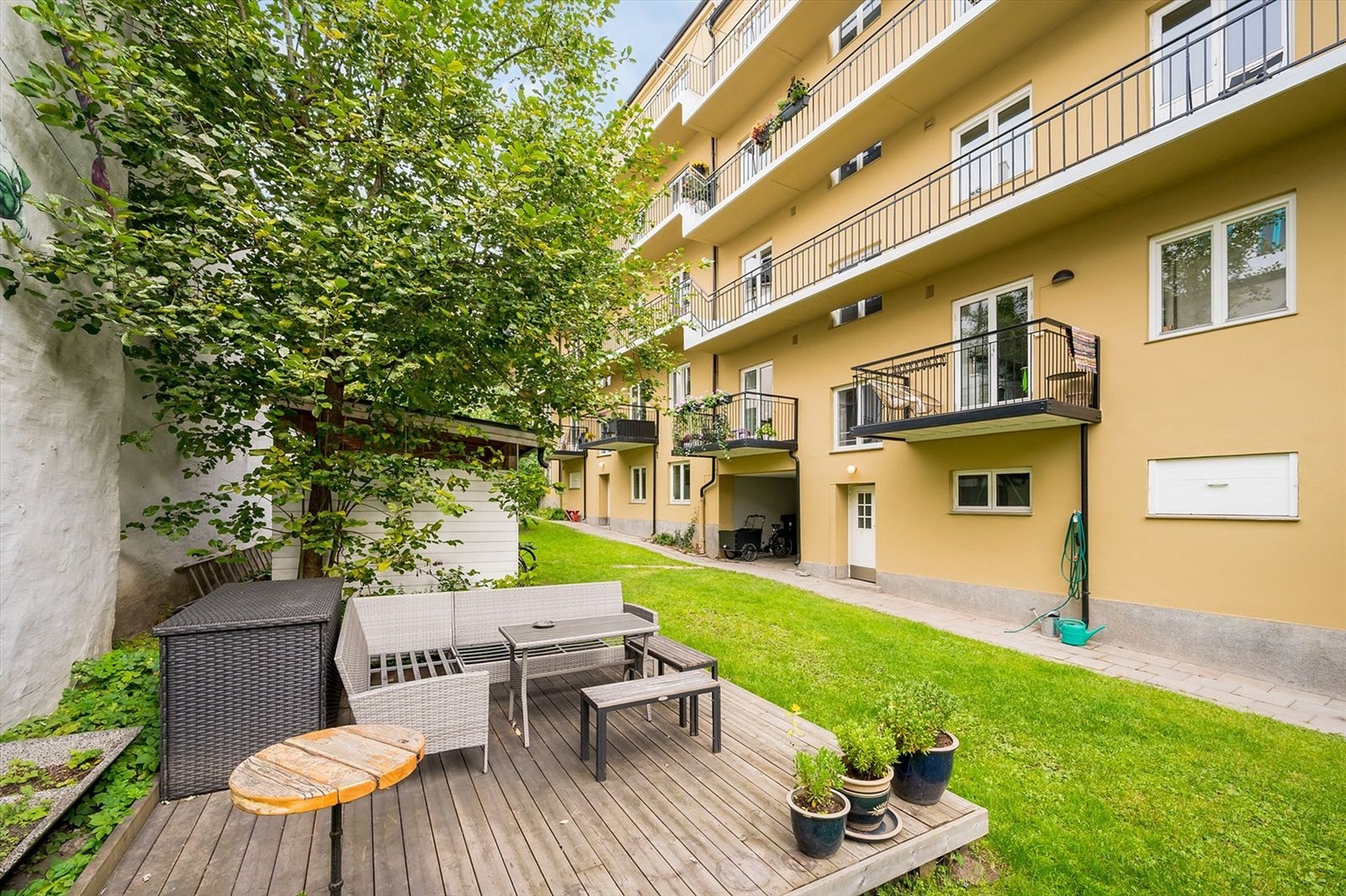 Sameiets bakgård er pent opparbeidet med gressplen, sittegrupper og diverse beplantning. Galleribilde