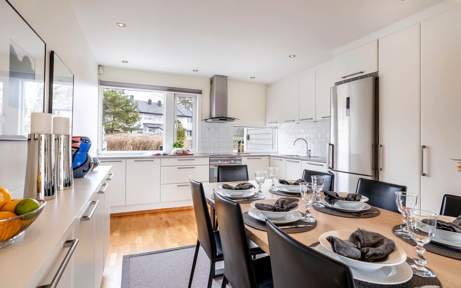 Kjøkkenet har et lys og stilren innredning plassert i romslig L-form, i åpen løsning til stuen. Innredningen har takoppforede skap, lyse, glatte fronter og benkeplate i grå laminat med nedfelt vaskekum. Galleribilde