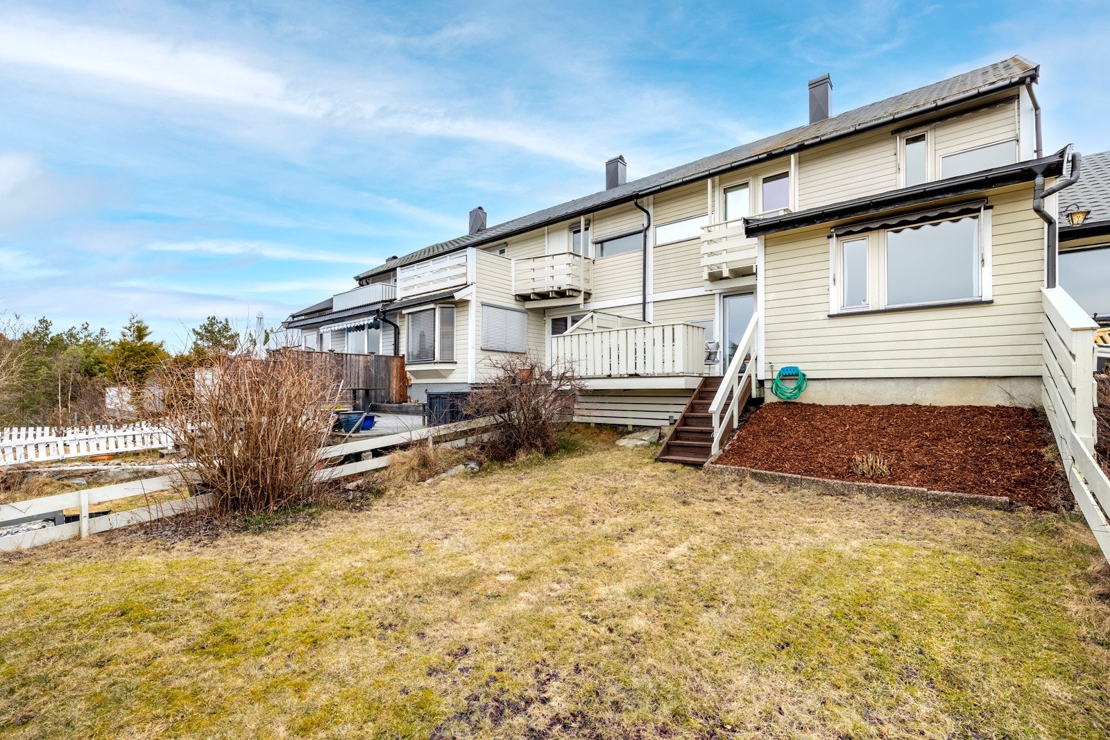 Fra terrassen er det trapp ned til egen, inngjerdet hageparsell med plen, prydbusker og vintergrønn hekk. Galleribilde