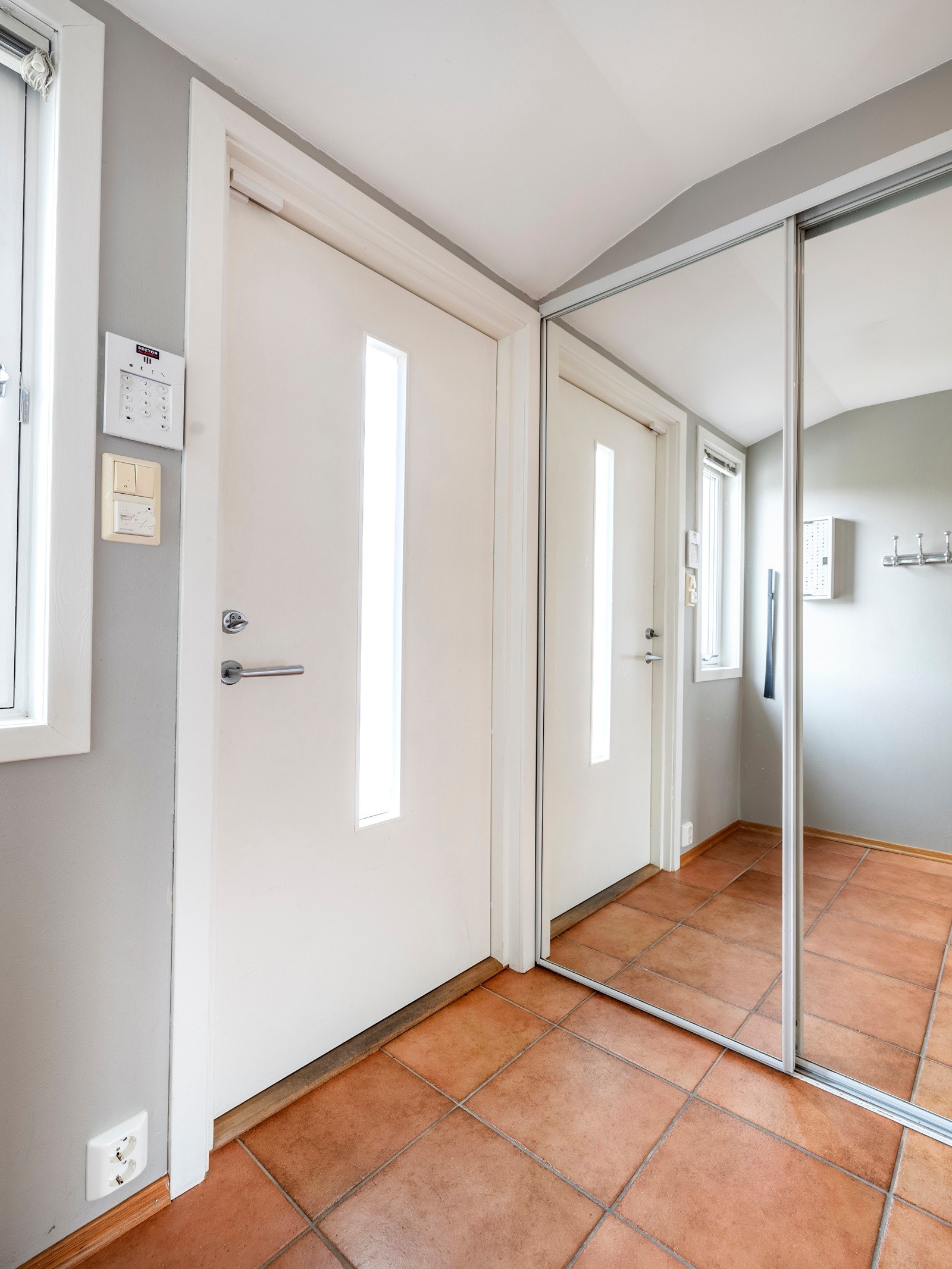 Entreen er lys og innbydende med glatte, gråmalte veggflater, listefri himling med dimmbare downlights og et vindu ved siden av yttedøren. Galleribilde