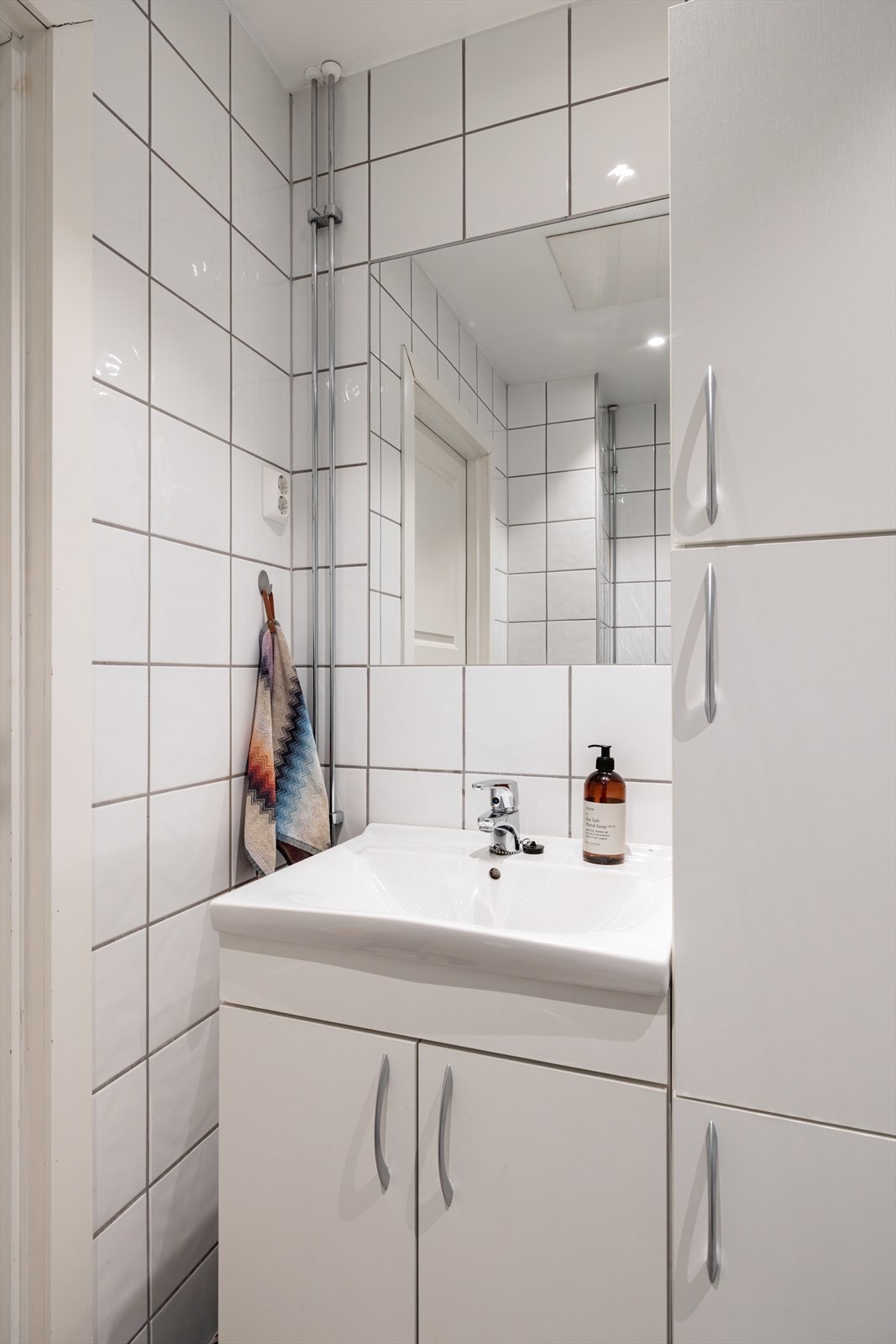 Badet er innredet med servant i skapseksjon og sideskap for oppbevaring. Galleribilde