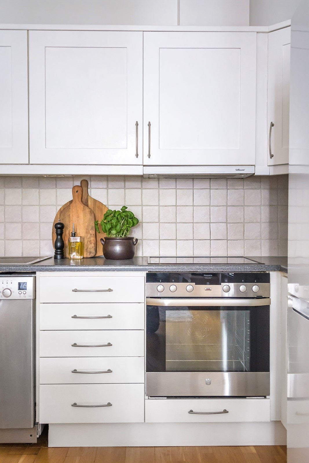 Hvit, stilren kjøkkeninnredning med benkeplate av laminat. Alle hvitevarer medfølger. Galleribilde