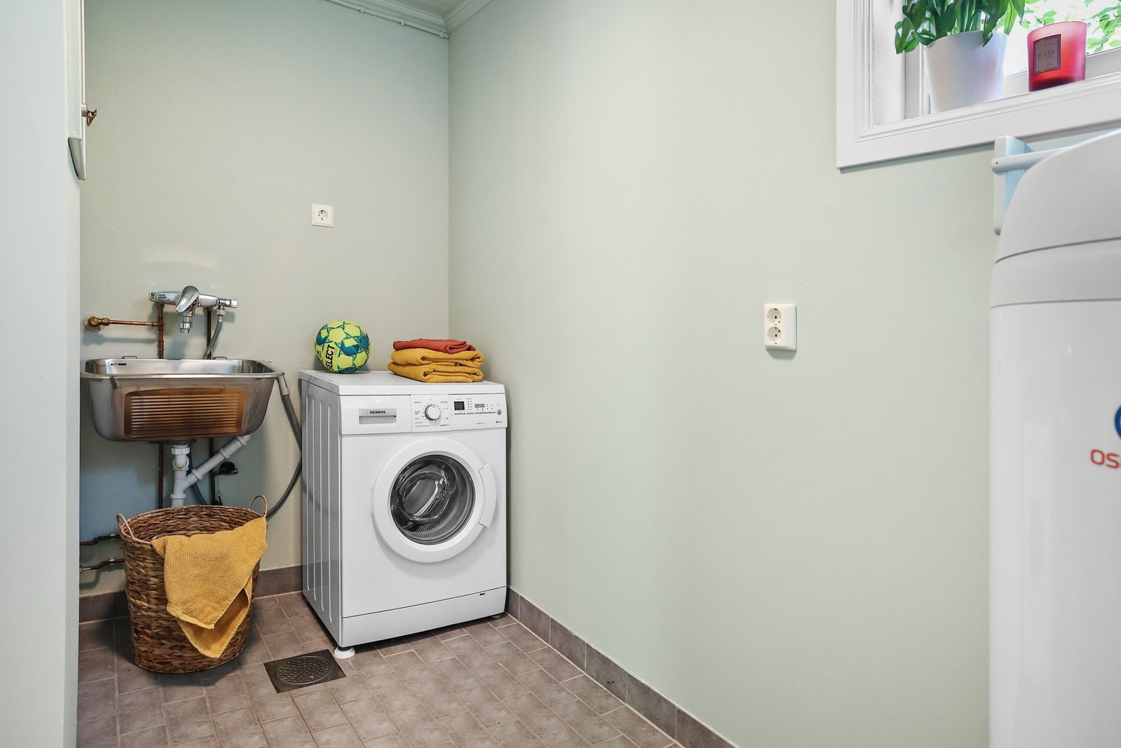 Praktisk vaskerom med opplegg for vaskemaskin. Galleribilde