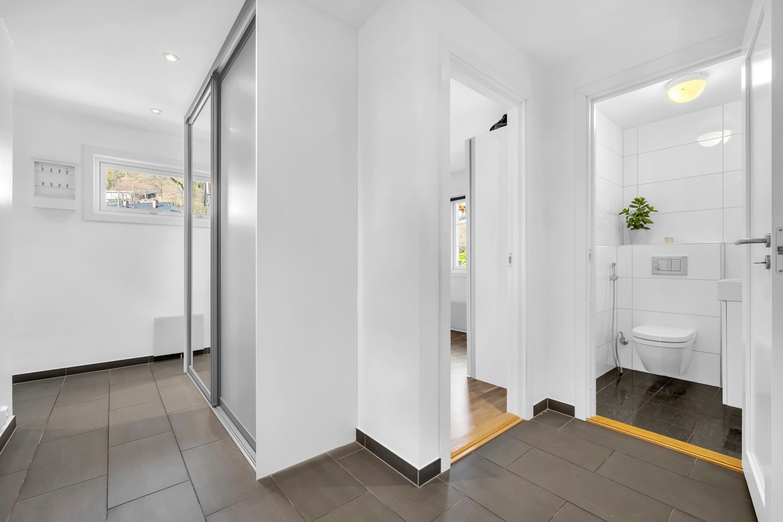 Romslig entrè med skyvedørsgarderobe Galleribilde