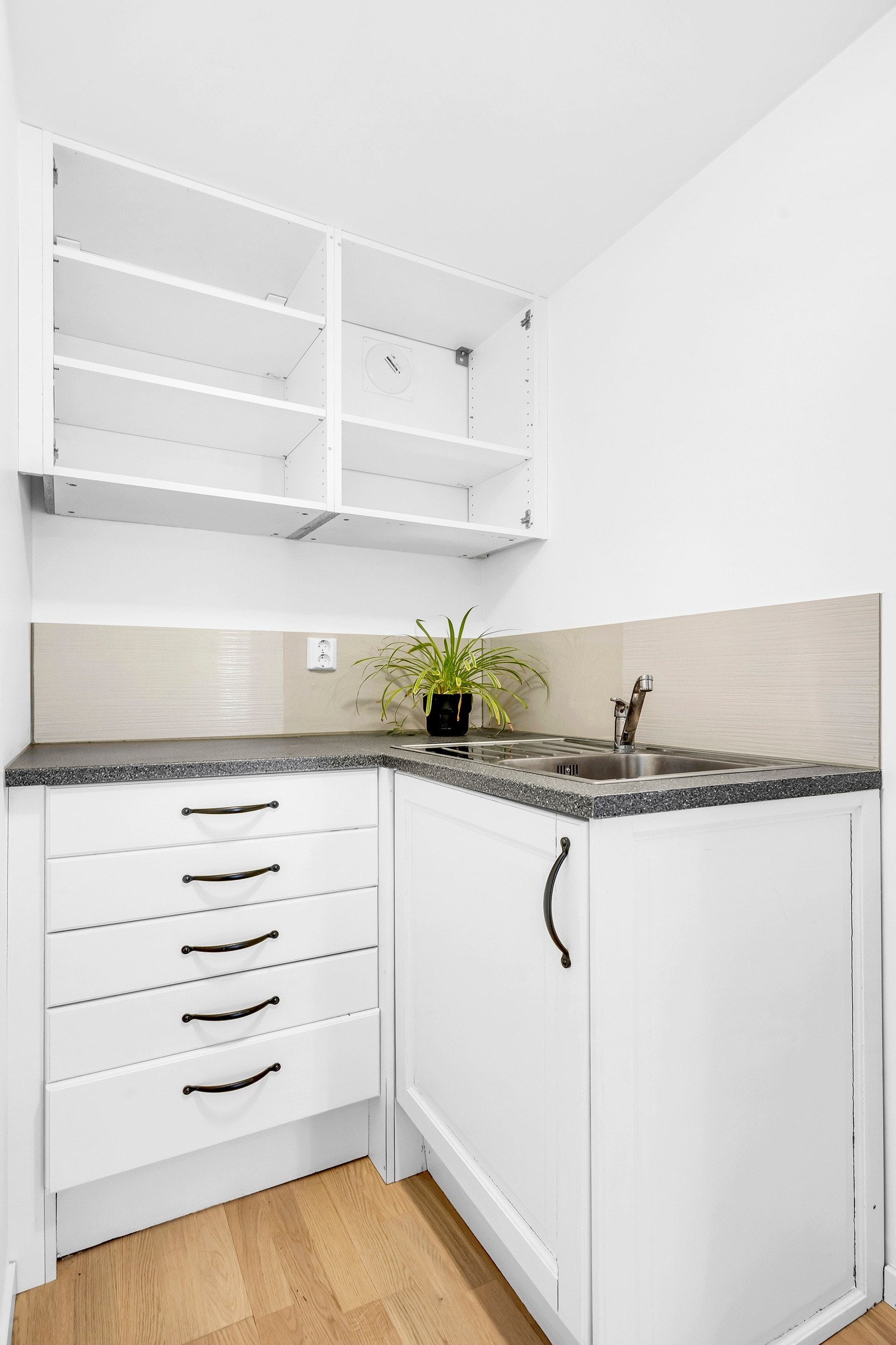 Mini kjøkken med noe skap og skuffer, samt vask Galleribilde