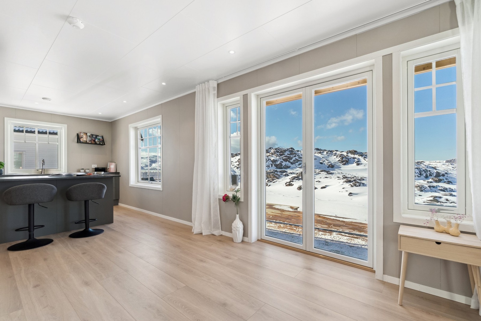Den solfylte spisestuen får naturlig lys fra store vinduer som ikke bare lyser opp rommet, men også gir deg et vakkert blikk ut mot omgivelsene. Galleribilde