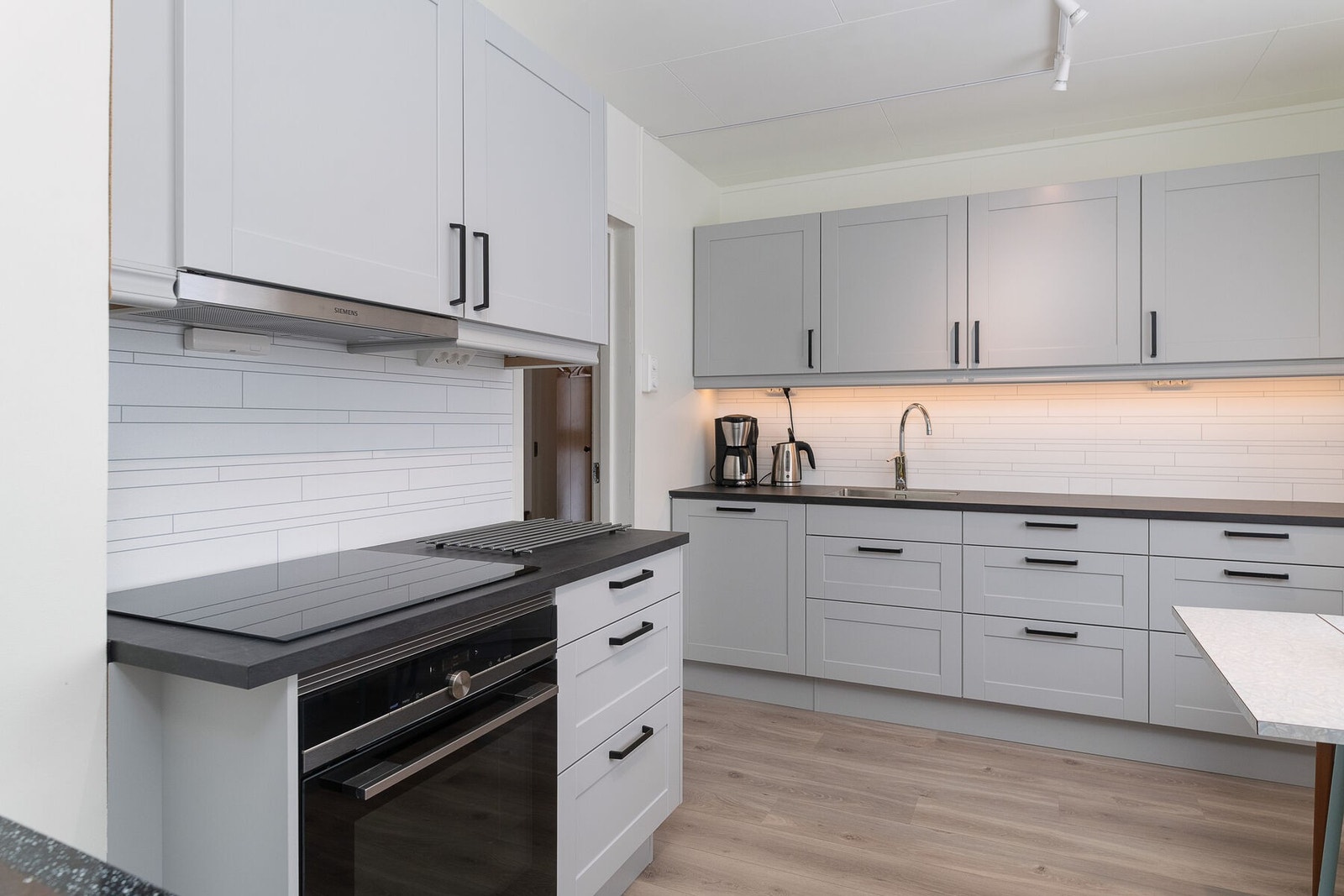 Kjøkkenet har integrerte hvitevarer som stekeovn, platetopp og oppvaskmaskin. Galleribilde