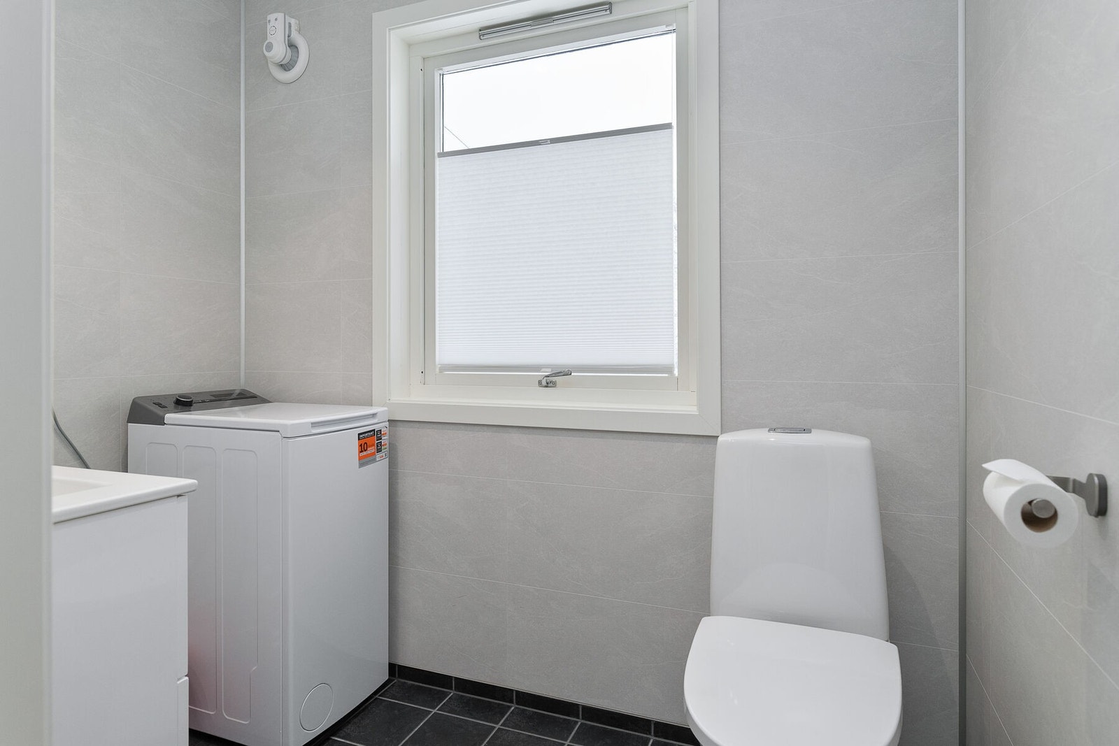 Bad/vaskerom ble også oppusset i 2022 og har opplegg for vaskemaskin, wc og servant på innredning. Galleribilde