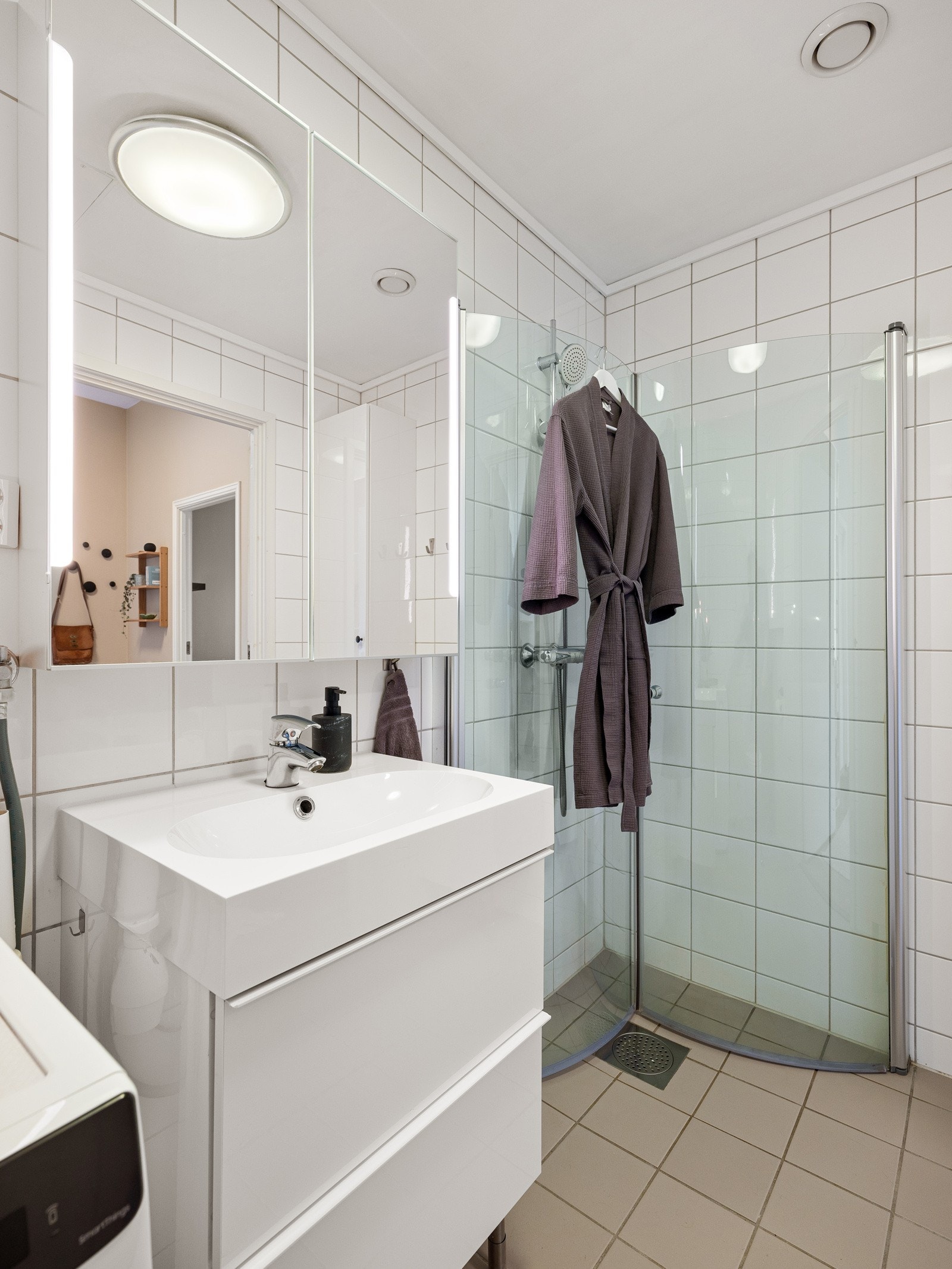 Rommet er innredet med dusjhørne, vegghengt toalett, opplegg for vaskemaskin og servant nedfelt i underskap. Galleribilde