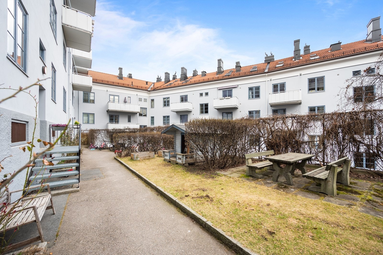 Hyggelig uteplass med sittegrupper, internveier, plen og beplantning Galleribilde