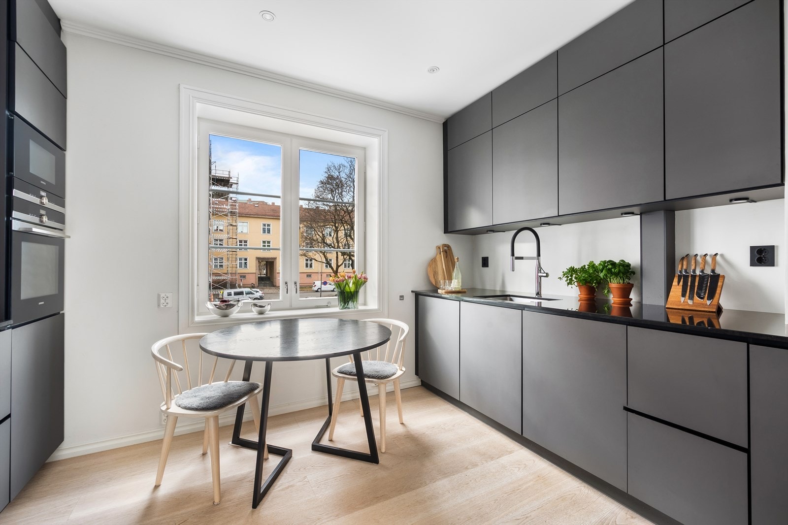 Stilsikker innredning med mørke, glatte fronter og benkeplate i stein. Galleribilde